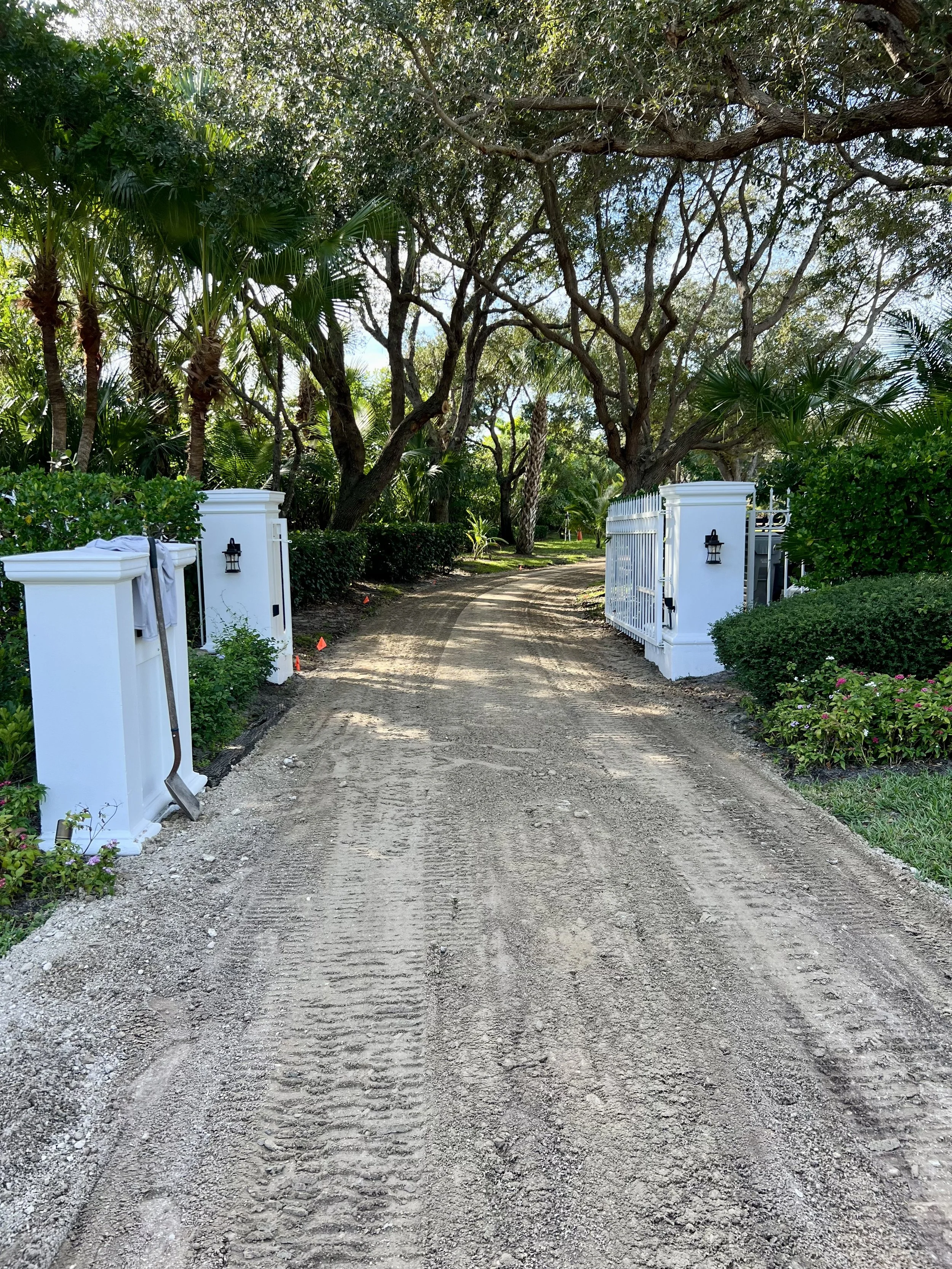 Skid steer installing a gravel driveway on a Florida residential property.