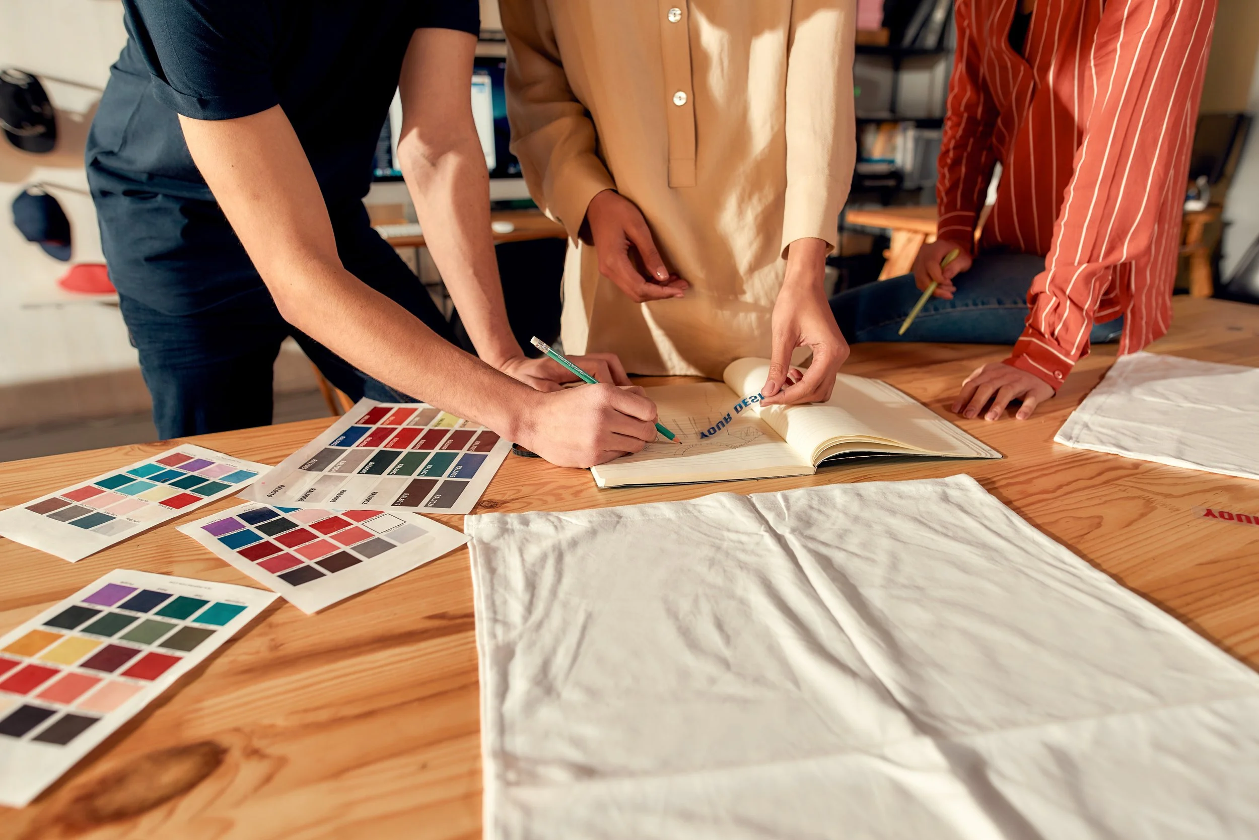 Clothing brand design team selecting fabrics and colors for a new production run.