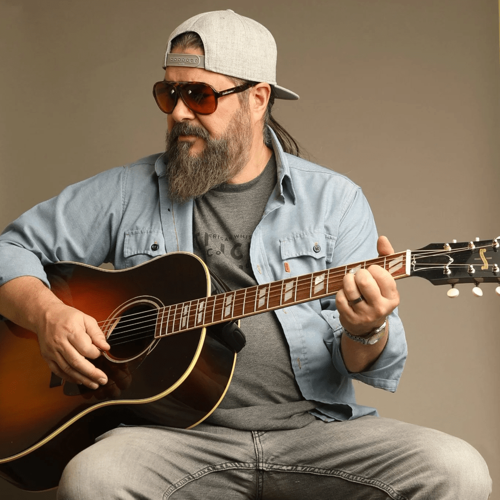 Sonny Reece seated with his acoustic guitar