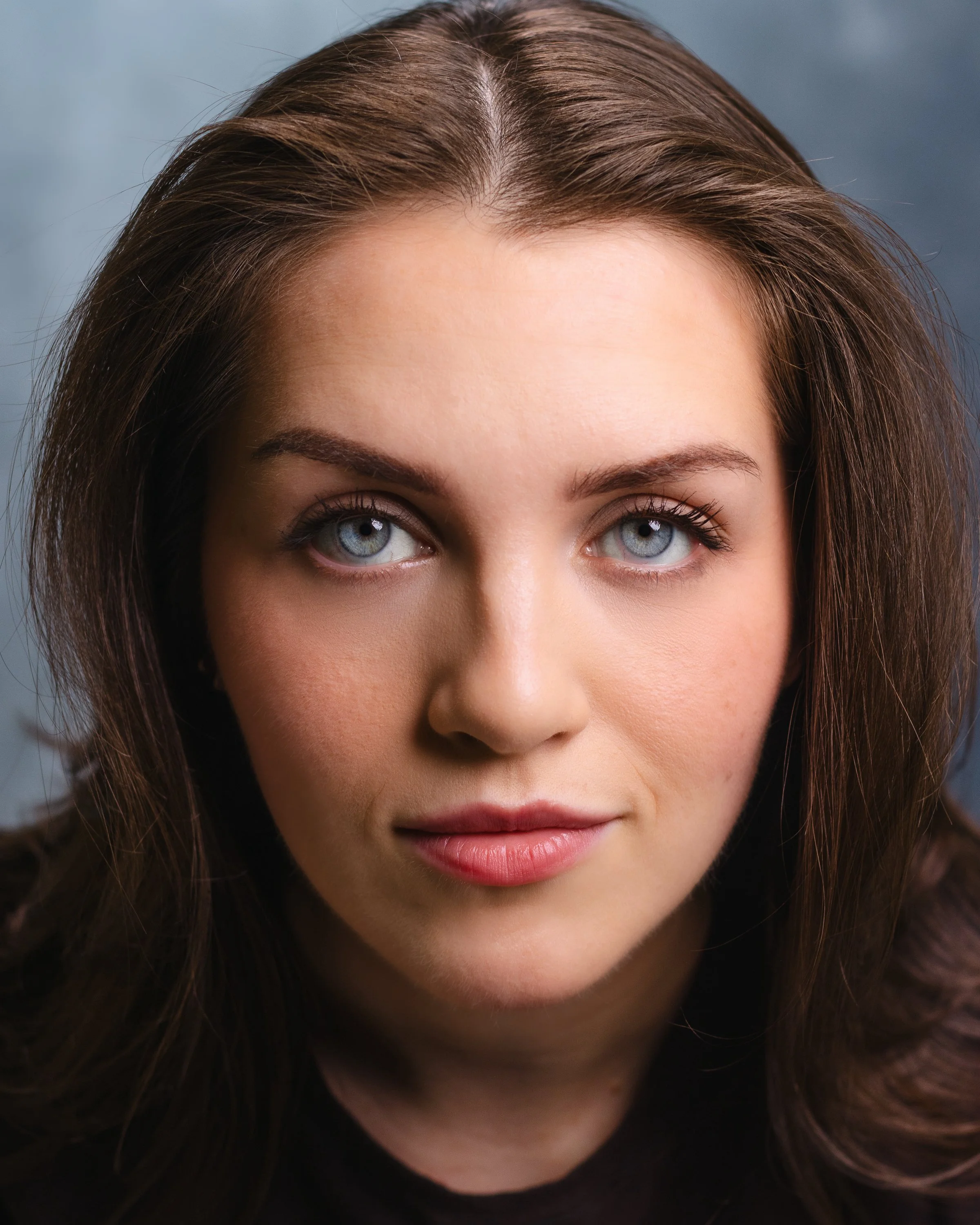 Carmiña Monserrat headshot with blue background