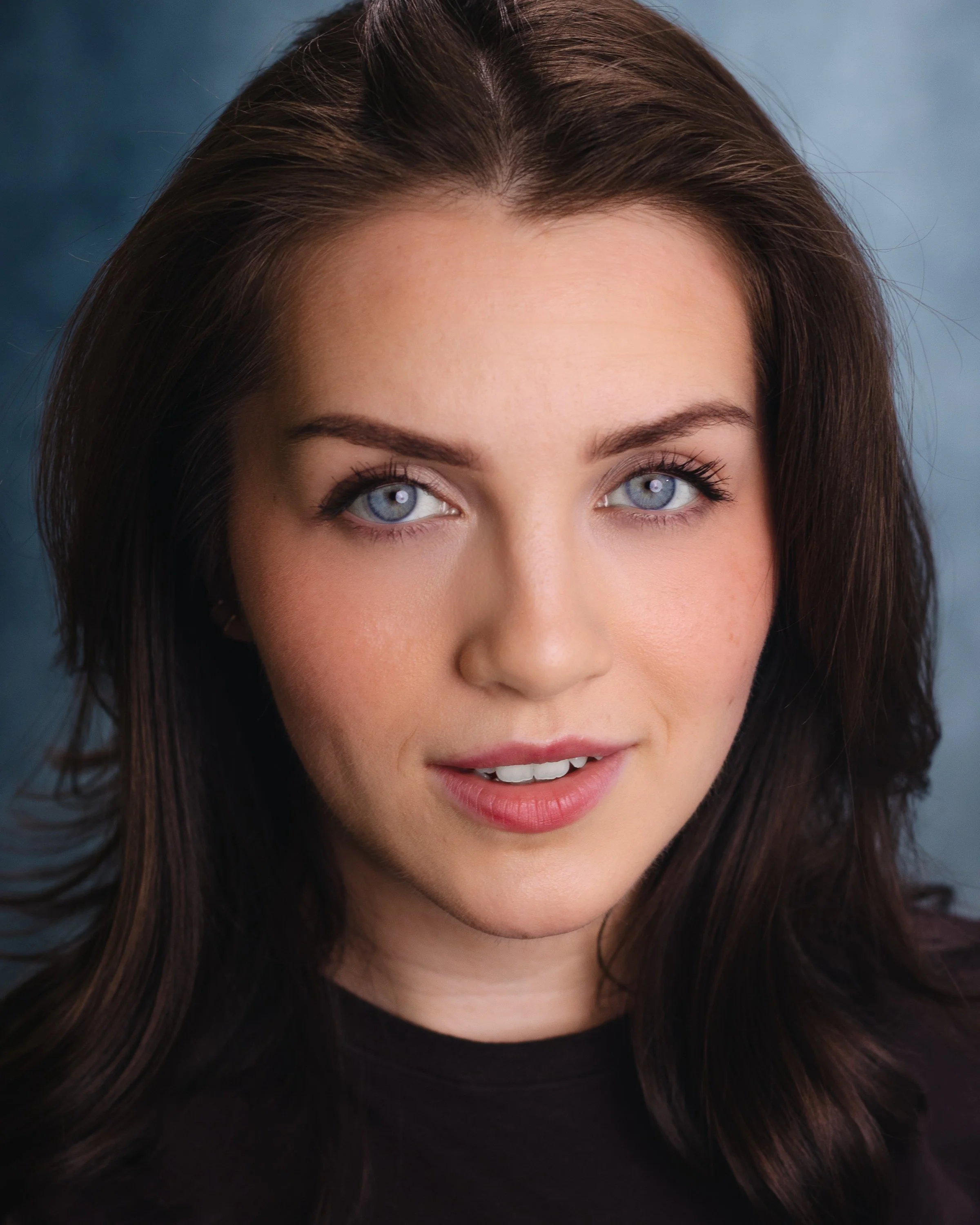 Carmiña Monserrat headshot with blue background