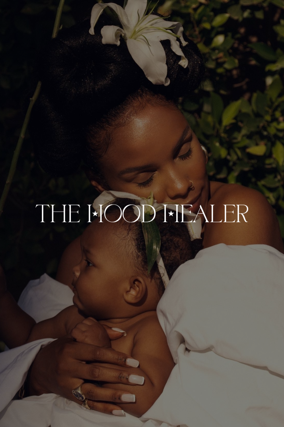 Portrait of a woman with bantu knots, adorned with white flowers, holding a child against a green leafy background, with the text 'The Hood Healer' overlaid.