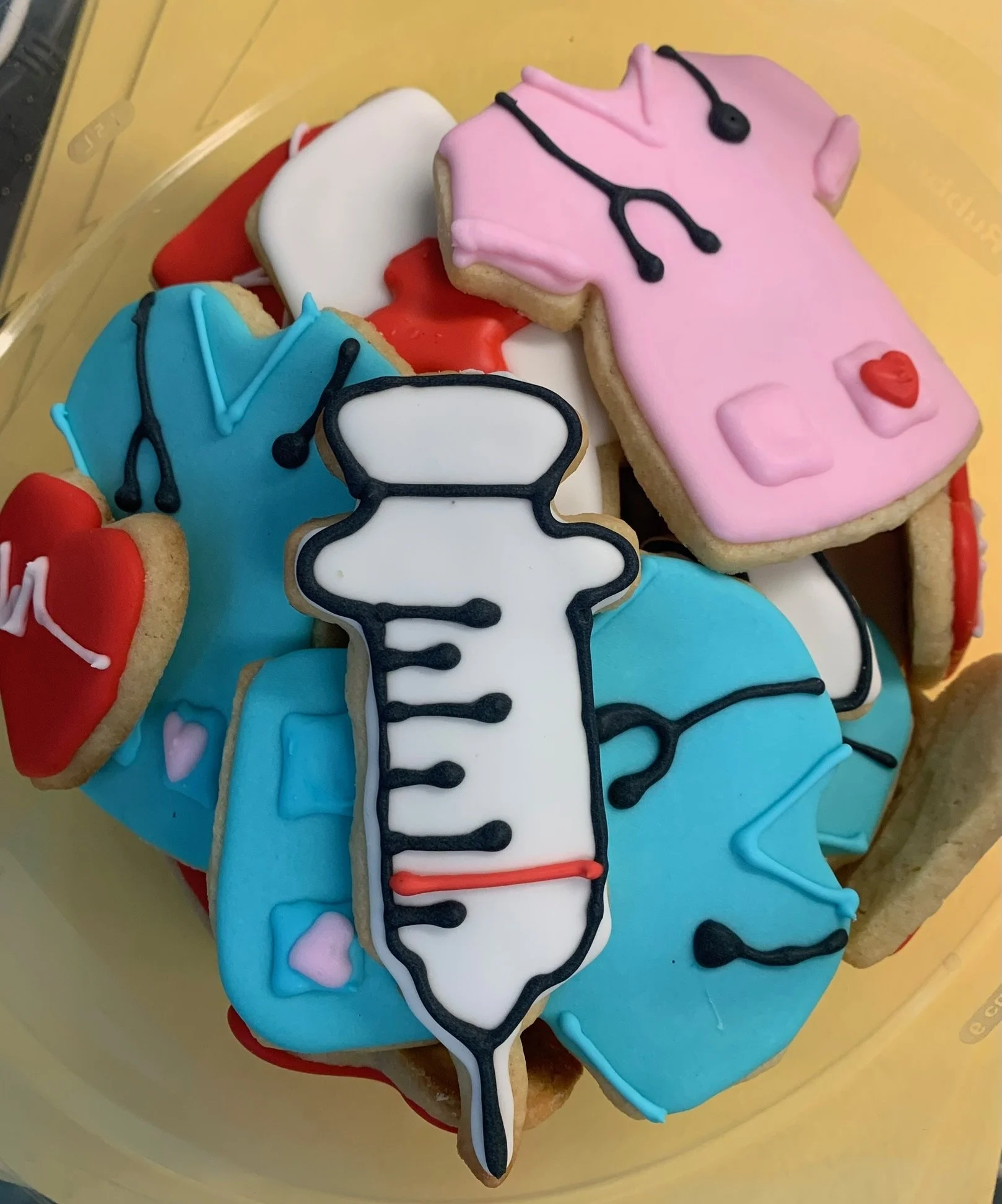 Cookies decorated with medical themes, including stethoscopes, a nurse's uniform, and a syringe, all with colorful icing.