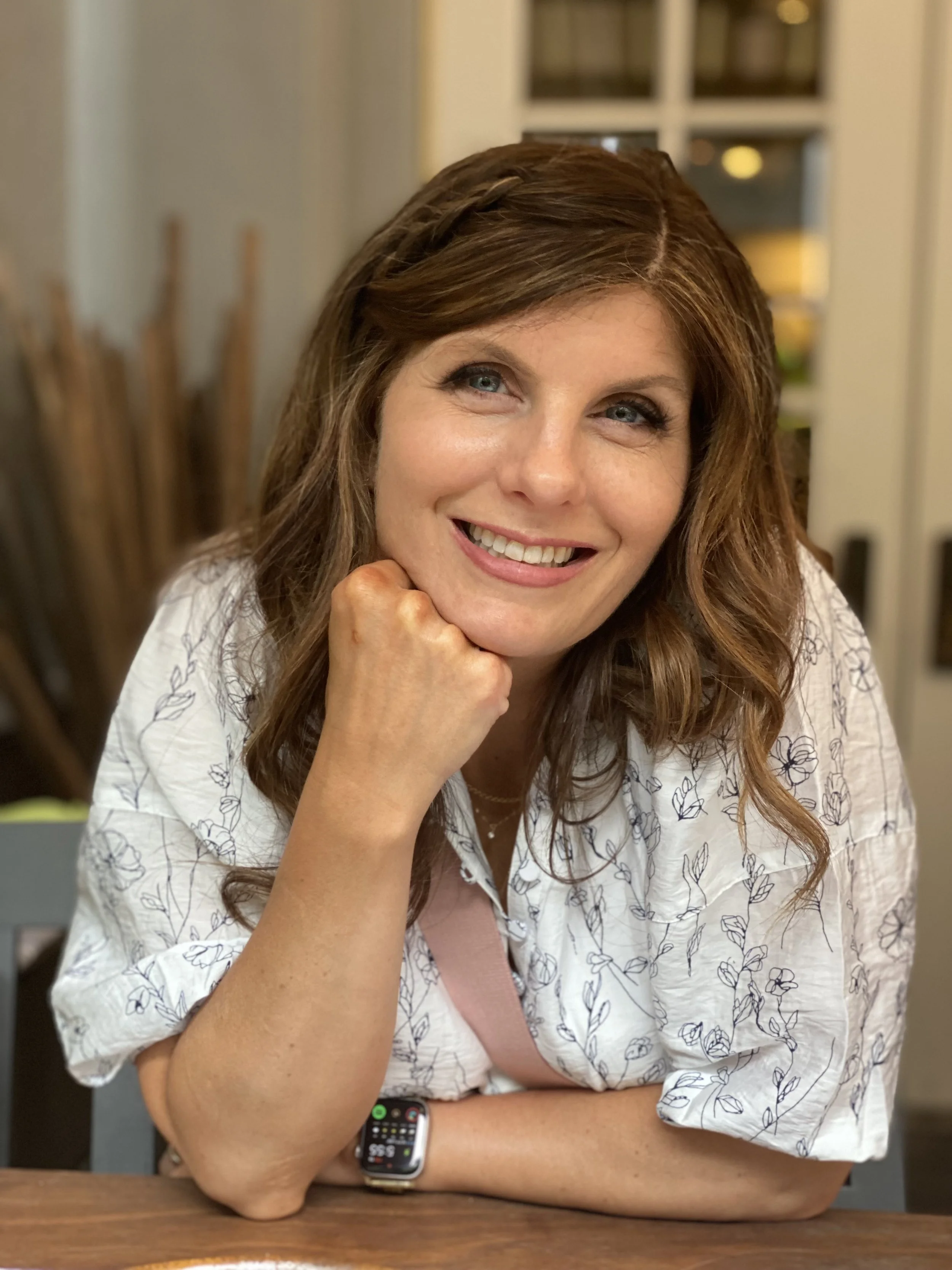 Headshot of Debi Bolster leaning in and smiling at the camera.
