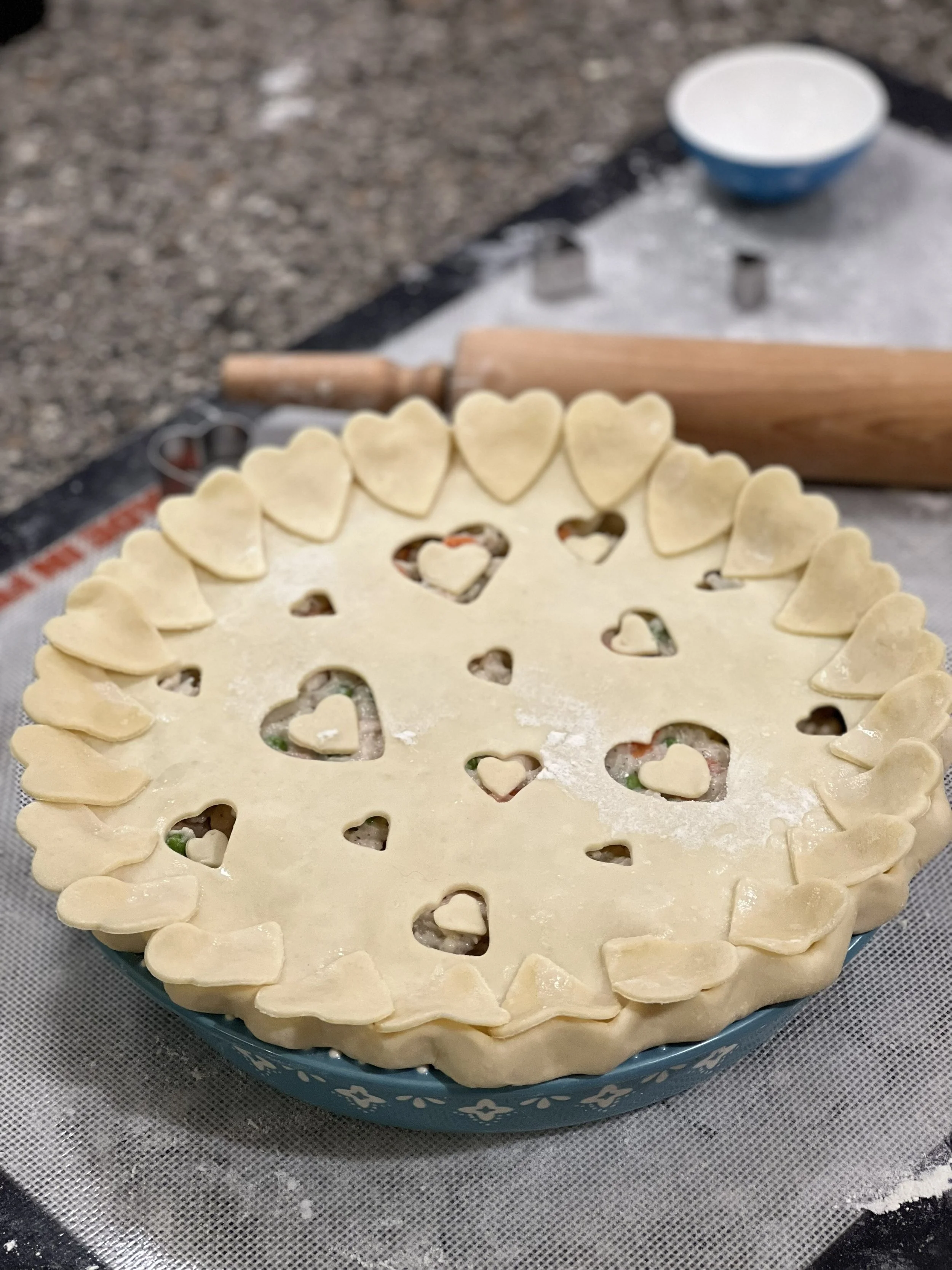 Pie being prepared to bake with heart-shaped cutouts in crust. Links to pie menu.