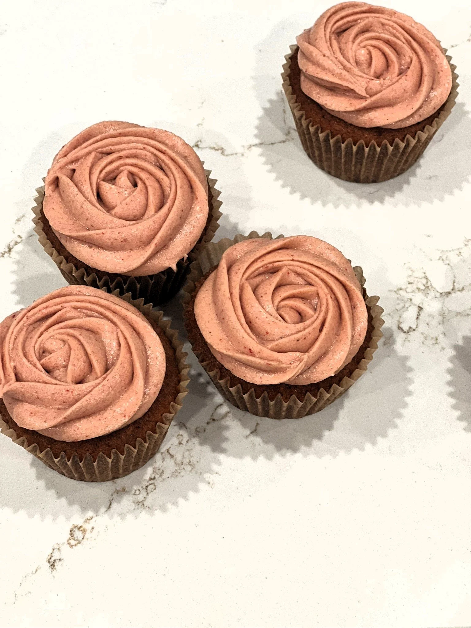 Dark colored cupcake with rose colored frosting. Links to cupcake menu.