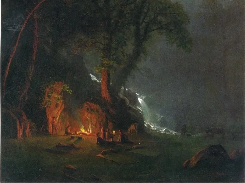 Snow-capped mountains in the background with brown and green rolling hills in the foreground, a modern building with wooden and stone elements on the hill.