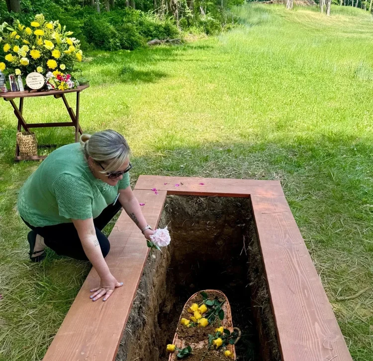 Staff adds flower to grave