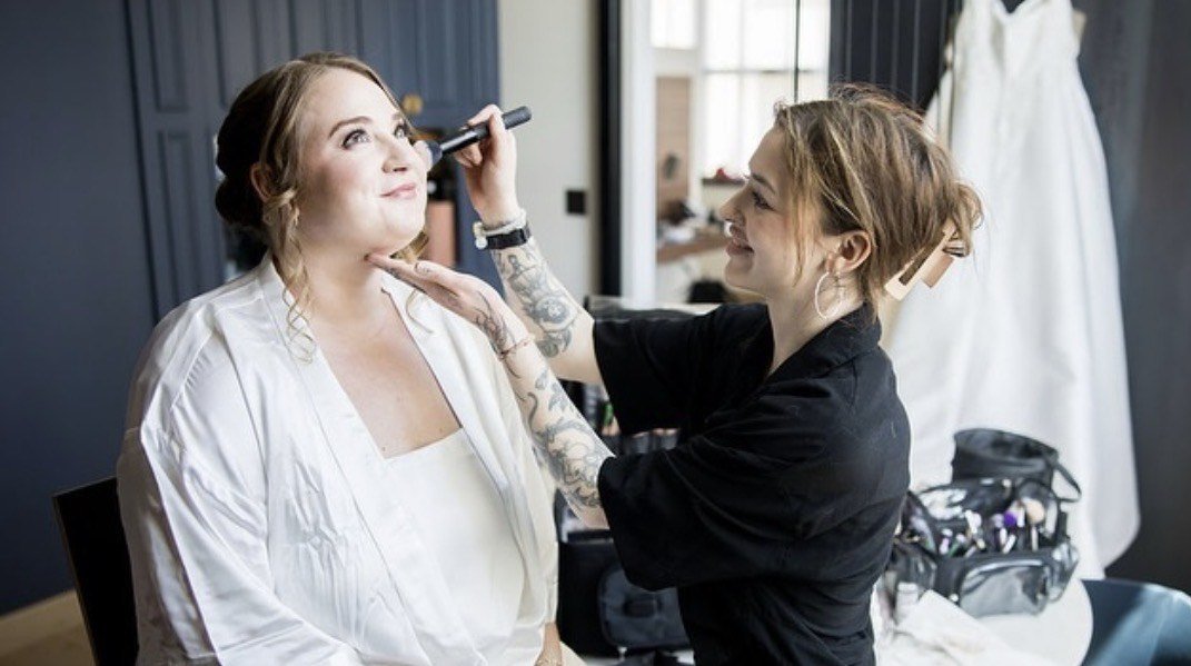Makeup artist applying makeup to bride for wedding day.