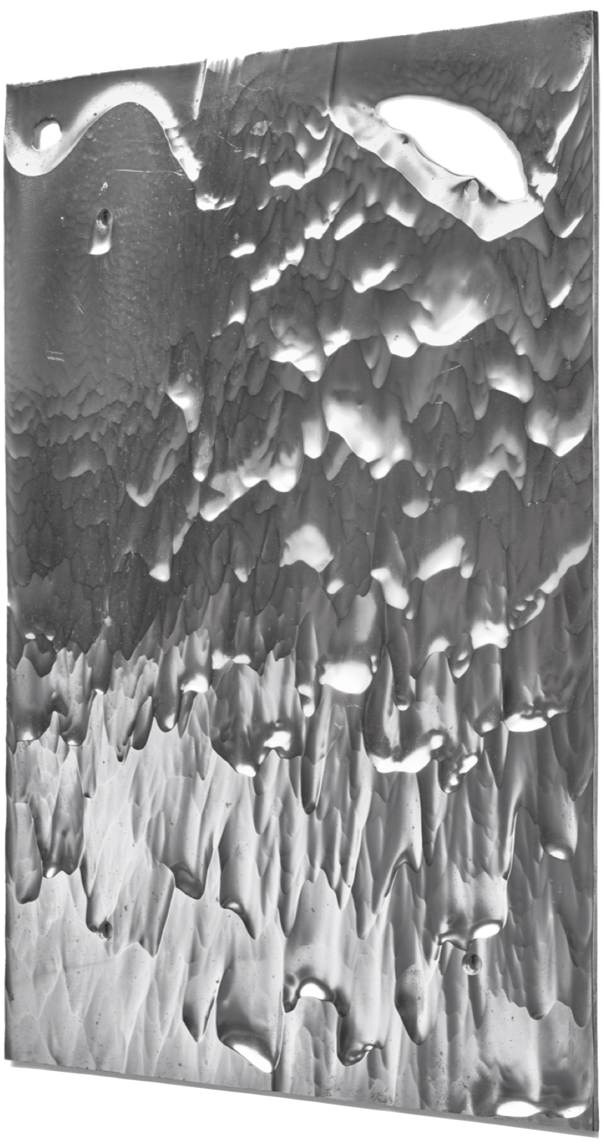 Close-up view of a metallic surface with various textures, ridges, and holes.