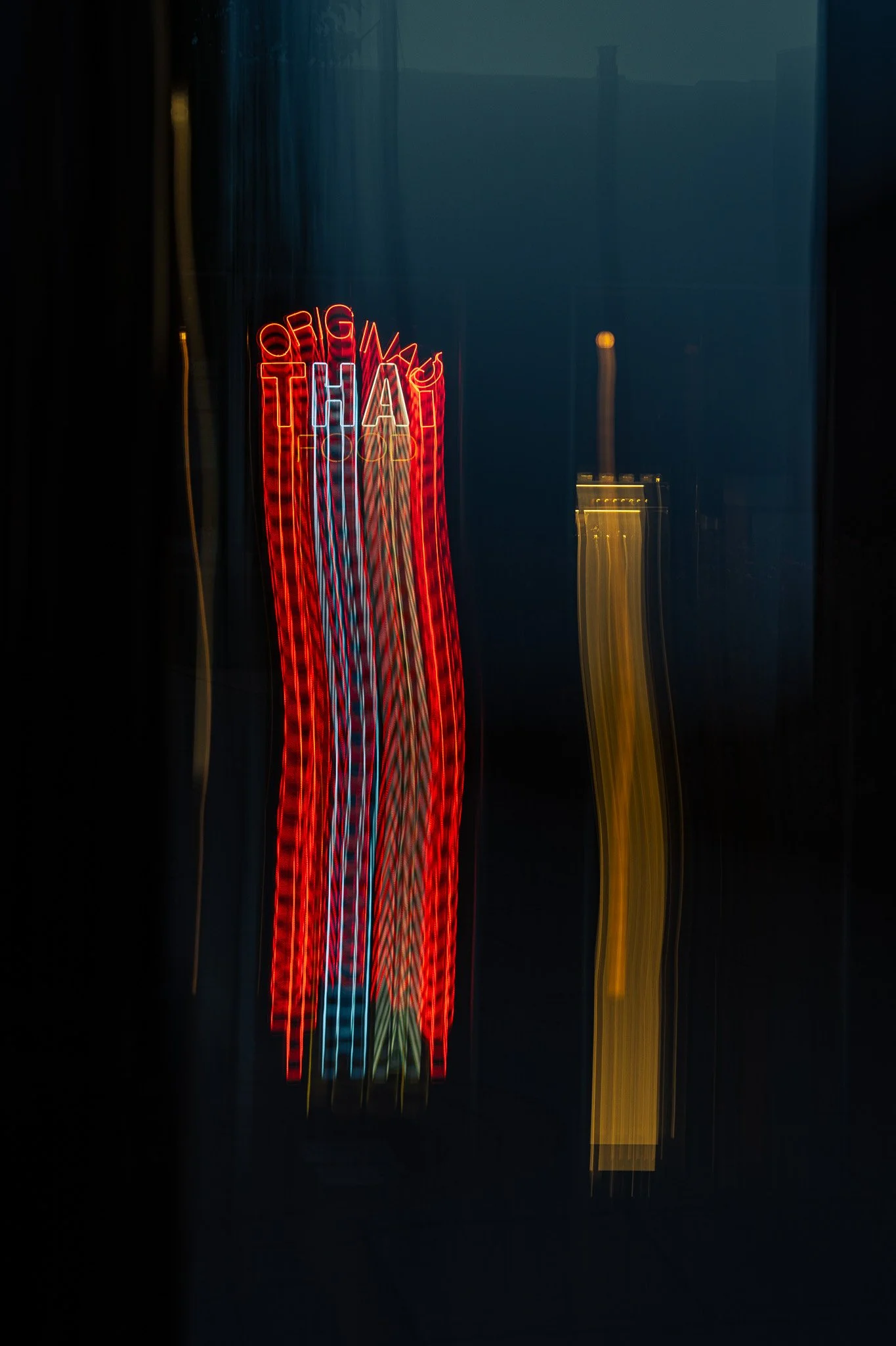 A light trail of a neon sign that says "Original Thai". Taken a blue hour in the Meadowlands area of Northern New Jersey.