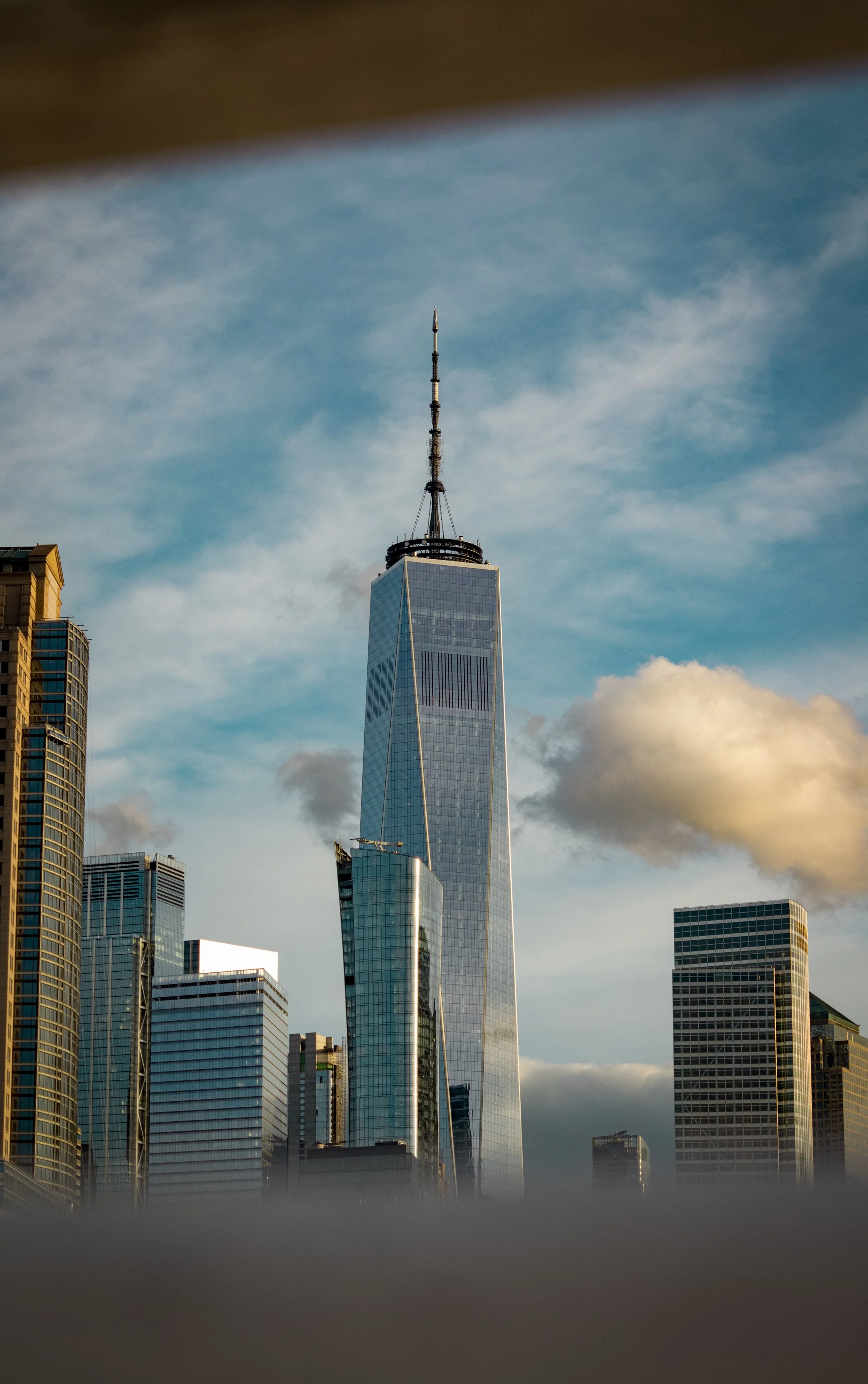 Photo of the Freedom Tower and some buildings in the Financial District of New York City through the rails of Pier 34 (Hudson River Trust)