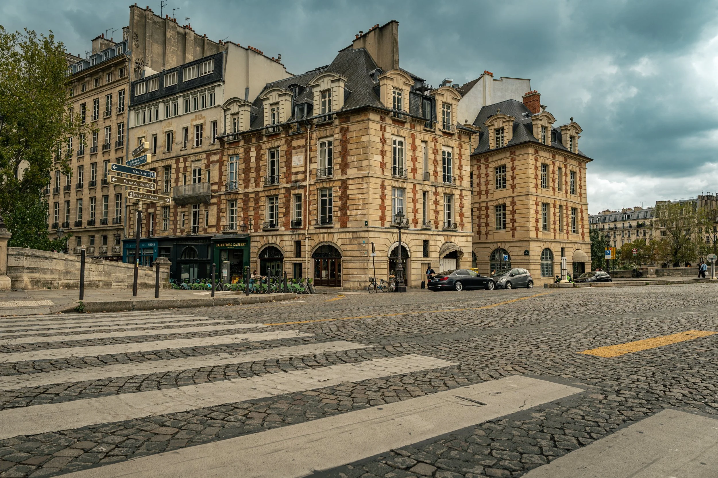 Buildings in the streets of Paris, France, with a crosswalk in the foreground.