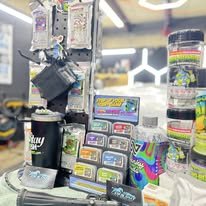 Display of various colorful gaming and collectible items, including card packs, a drink cup, and jars of candy.