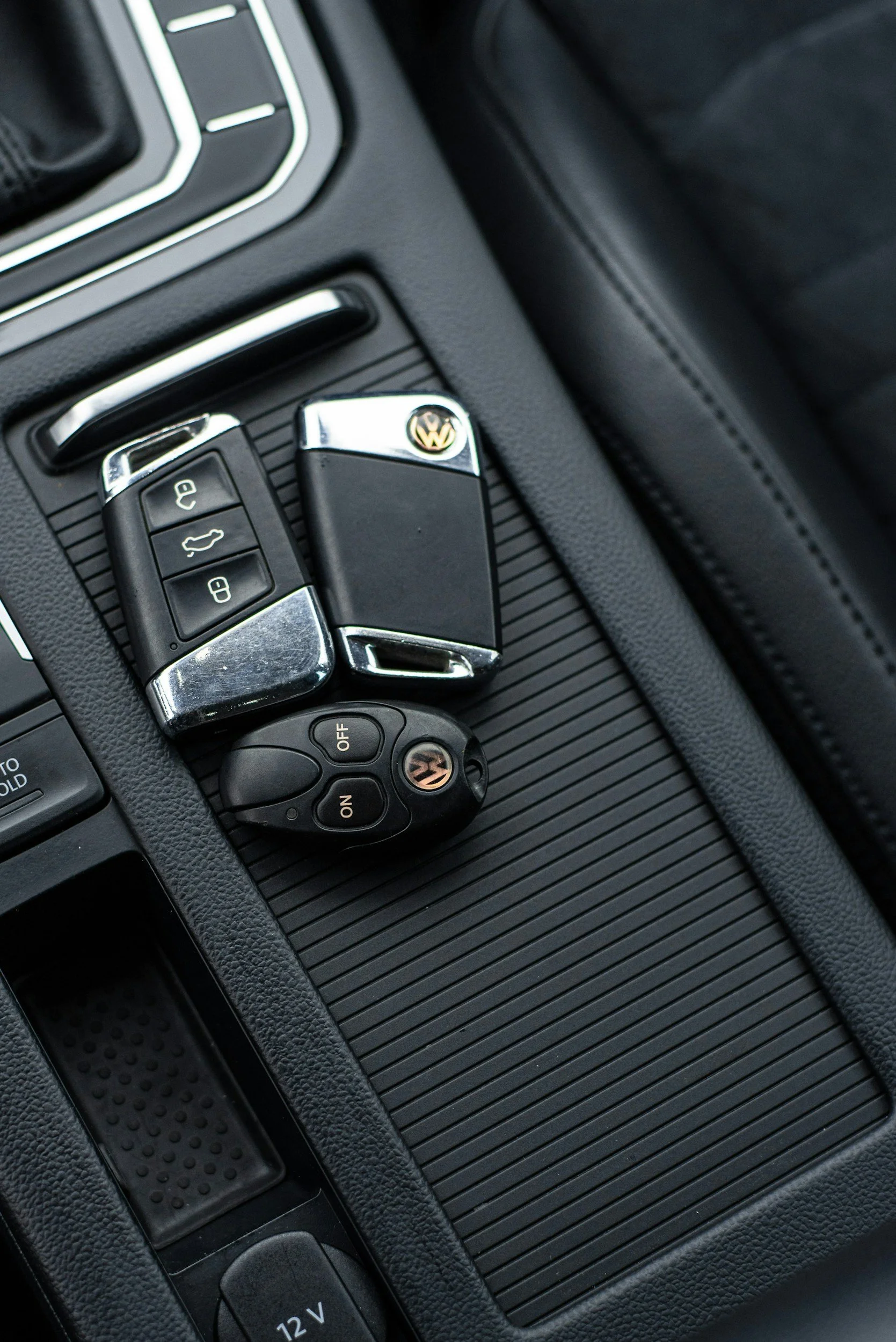 Car keys and remote fob placed on a car's center console.