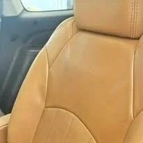 Beige car seat interior with visible stitching.
