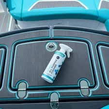 Spray bottle placed on a black rubber mat with blue trim, likely in an automotive or cleaning setting.