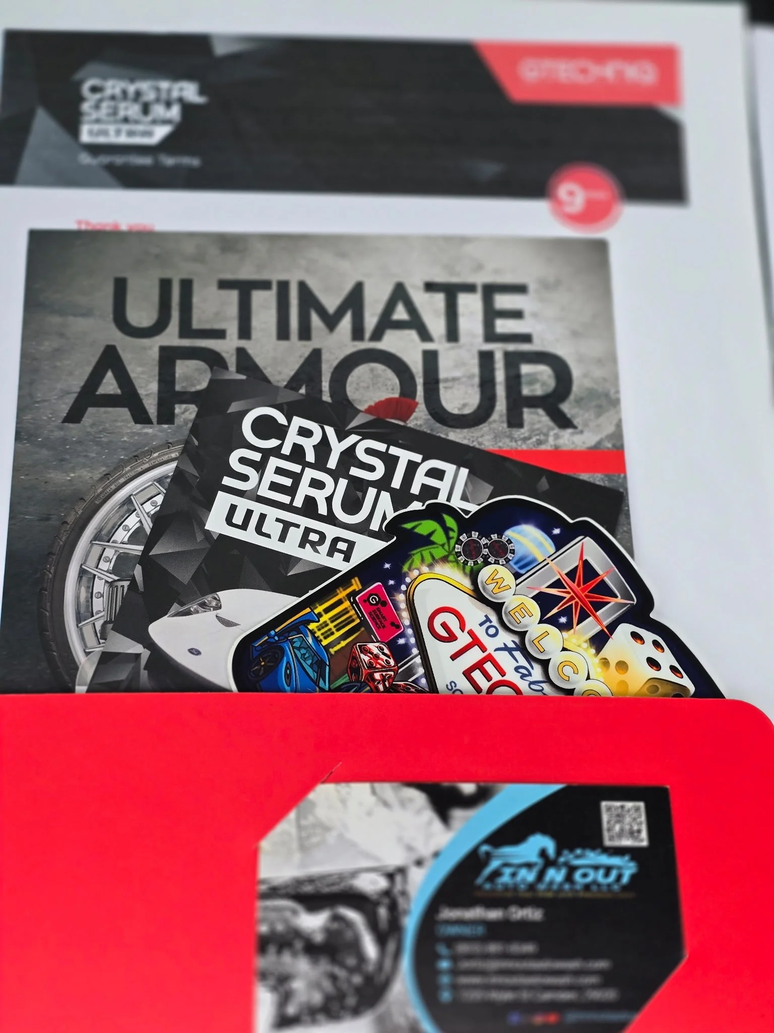 A Red cardboard seat back organizer with a black and blue label, containing a social media or contact information card for a business named TOWN OUT.