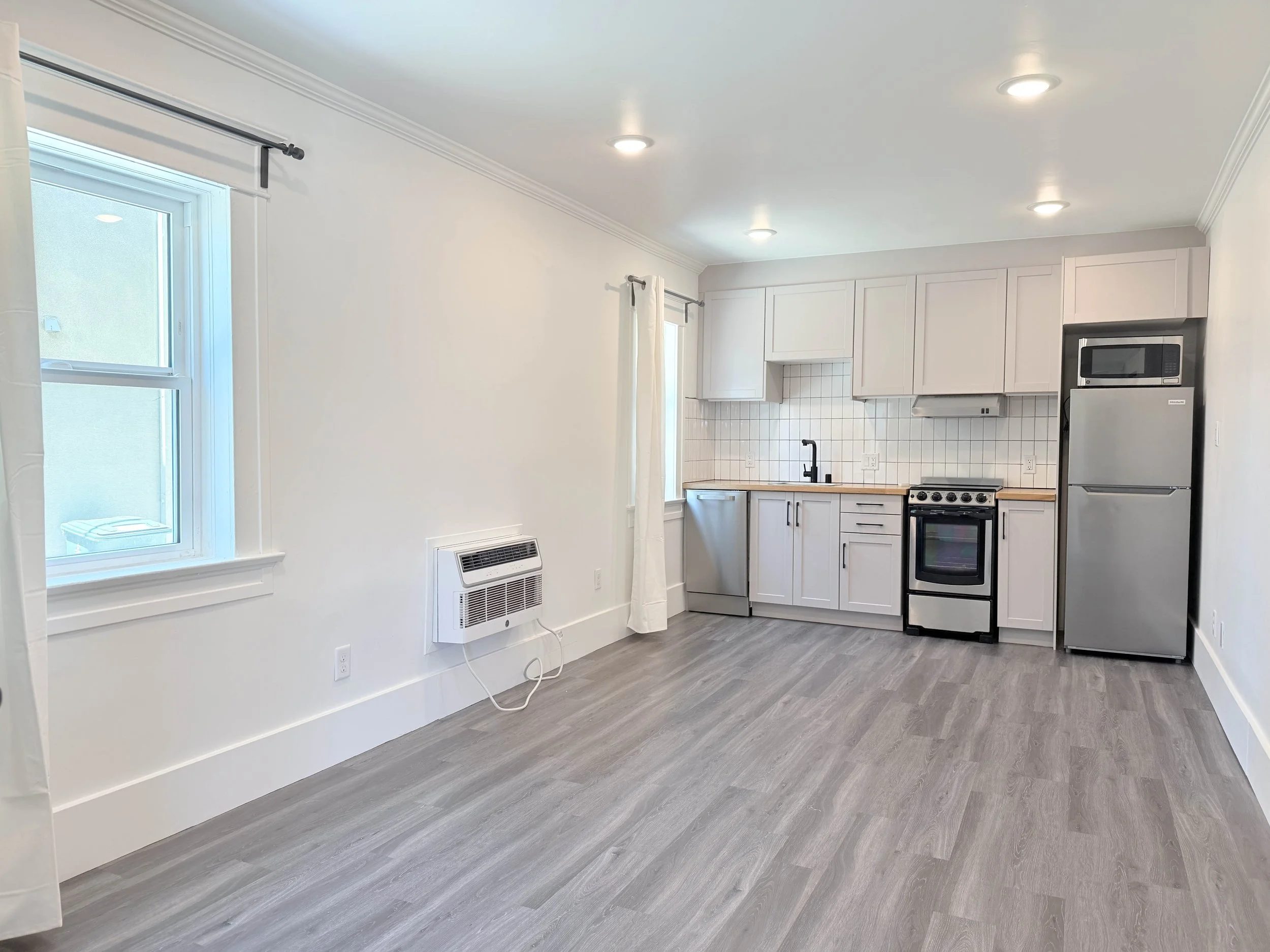 Floor plan of a small apartment with a living area, kitchen, bathroom, and bedroom with a balcony.