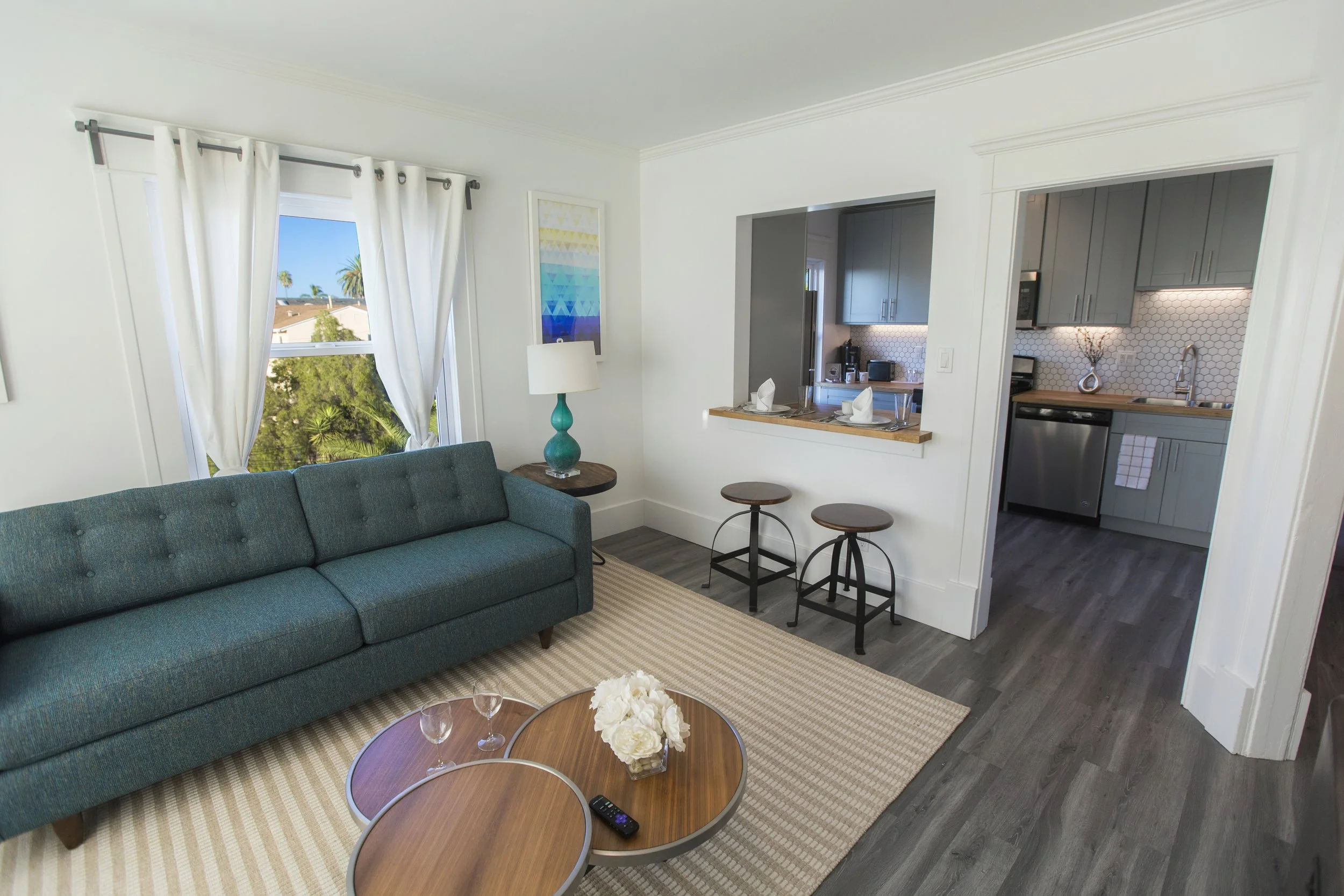 Floor plan of a small apartment with a living area, kitchen, bathroom, and bedroom with a balcony.