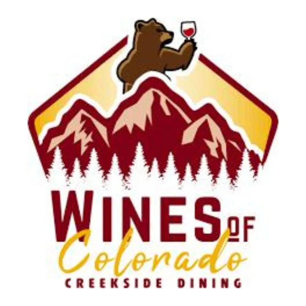 Logo for Wines of Colorado featuring a bear holding a glass of red wine above a mountain landscape with pine trees, with text 'Wines of Colorado' and 'Creekside Dining'.