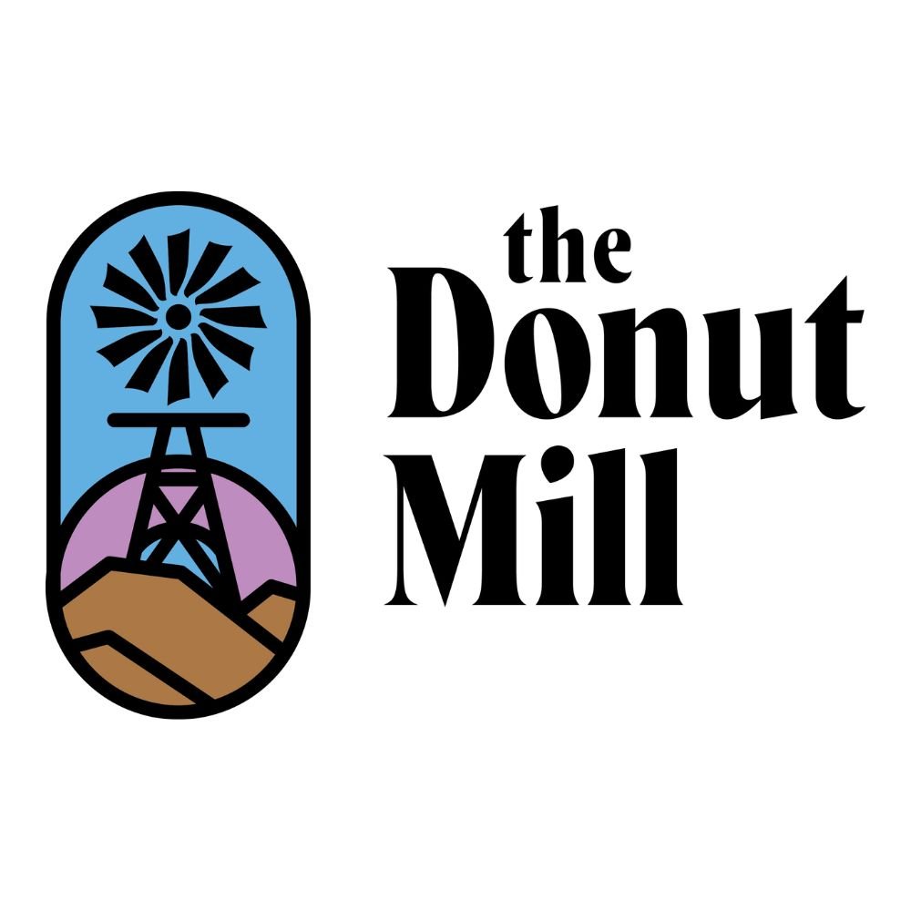 Logo for The Donut Mill featuring a stylized windmill with a blue sky, mountains, and a brown terrain background.