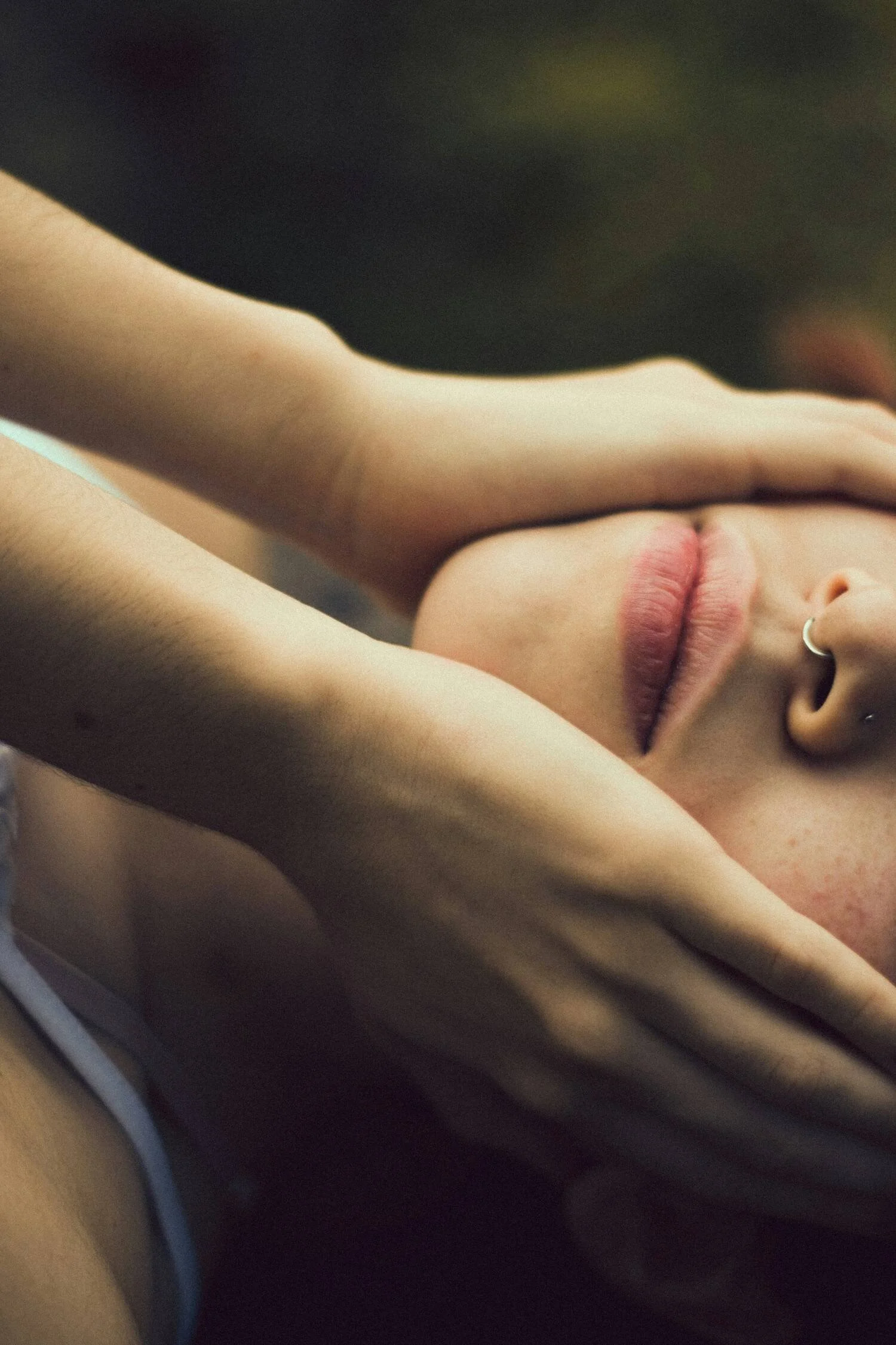 Close-up of a person's face with closed eyes, touching her face and feeling her skin to reconnect