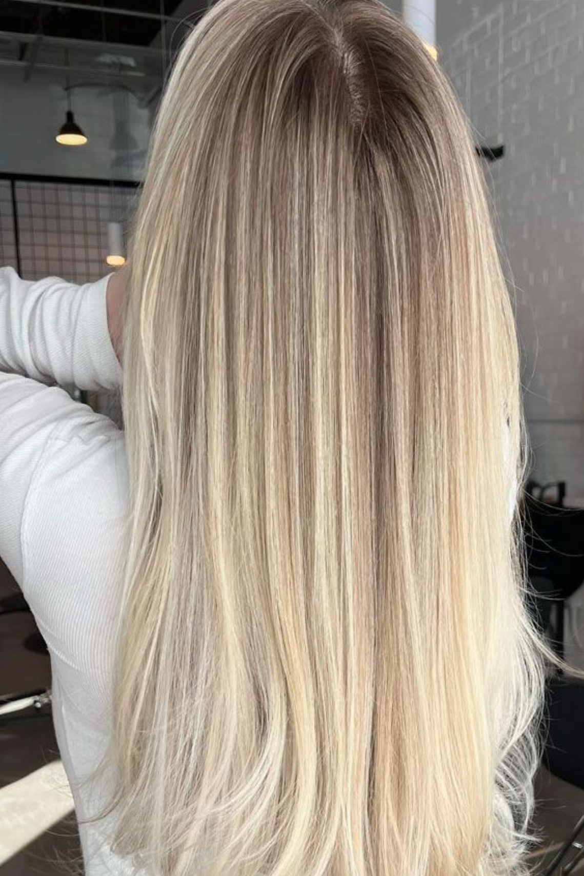 Long, straight, blonde hair with subtle highlights, seen from the back.