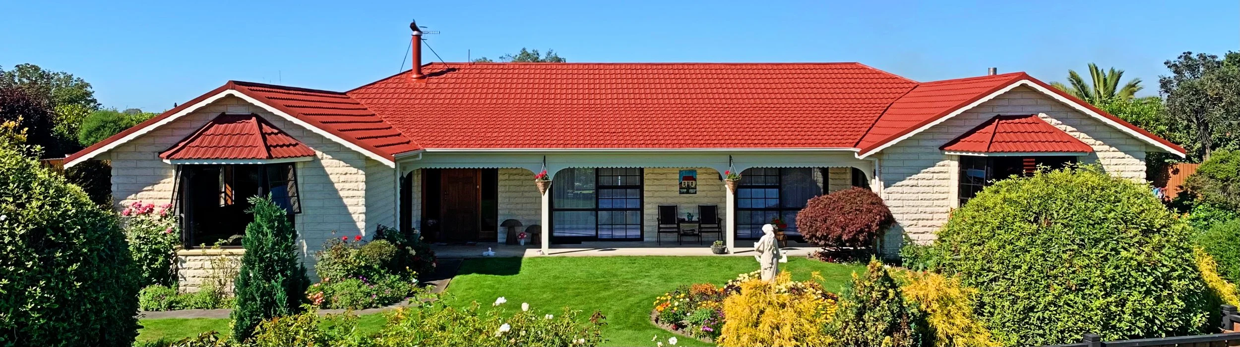 A tiled roof that has been painted red by a local south canterbury painter who provides exterior painting the painter is called Emerge Painting who are based in timaru region and service from timaru to geraldine