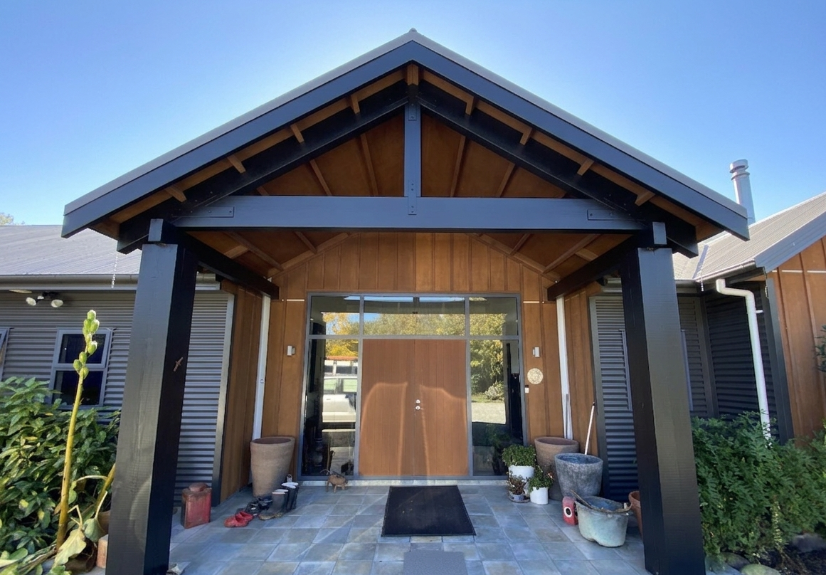 Front entrance of a house with wooden and black accents, glass door, tiled walkway painted in wattyl solagard by a local painter in Geraldine and Timaru