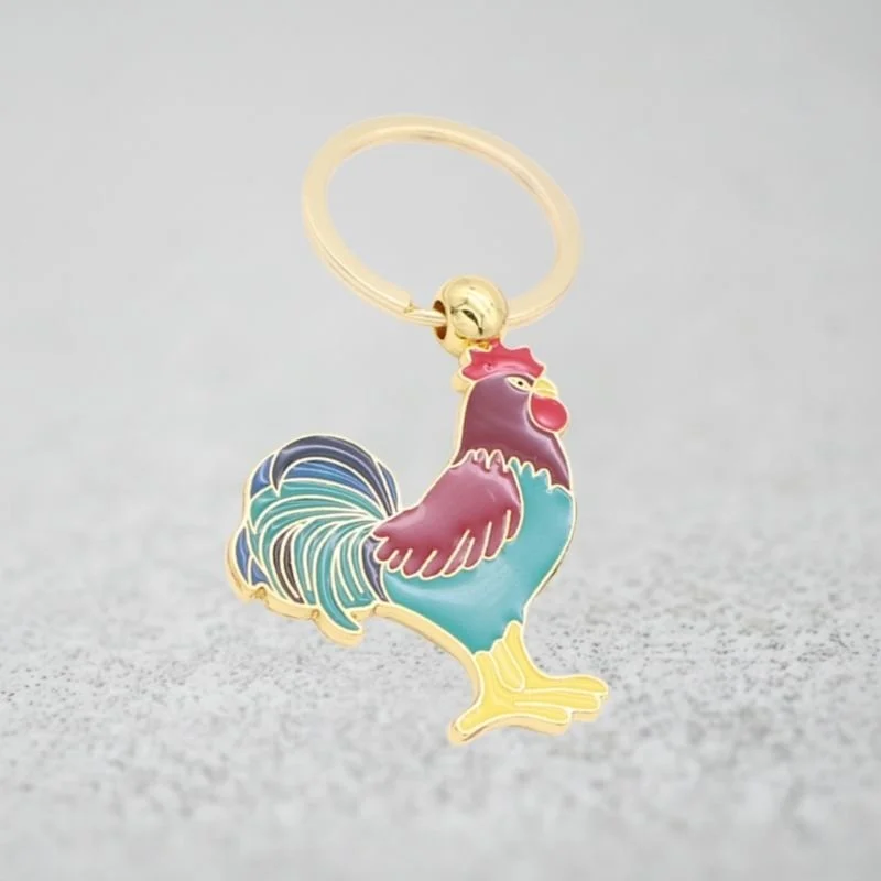 Exemple d’objet média sur mesure : porte-clés émaillé personnalisé en forme de coq, finitions premium.
