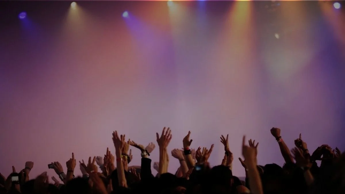 Public en concert avec lumières de scène, univers événementiel pour objets média personnalisés.