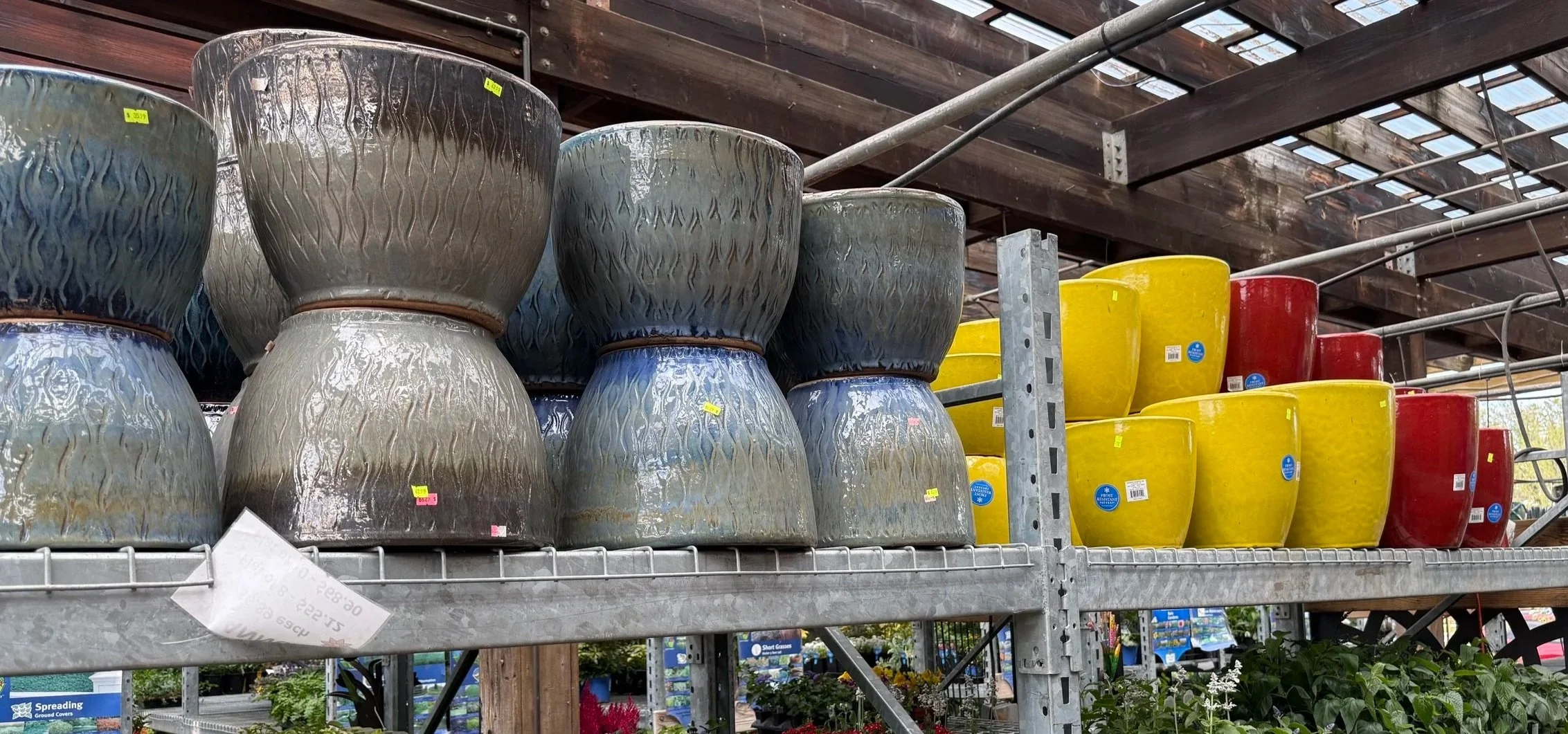 Colorful flower pots on metal shelves at Allemon’s Landscape Center, Detroit, Michigan serving the Grosse Pointe, St. Clair Shores, and Detroit Communities since 1929.