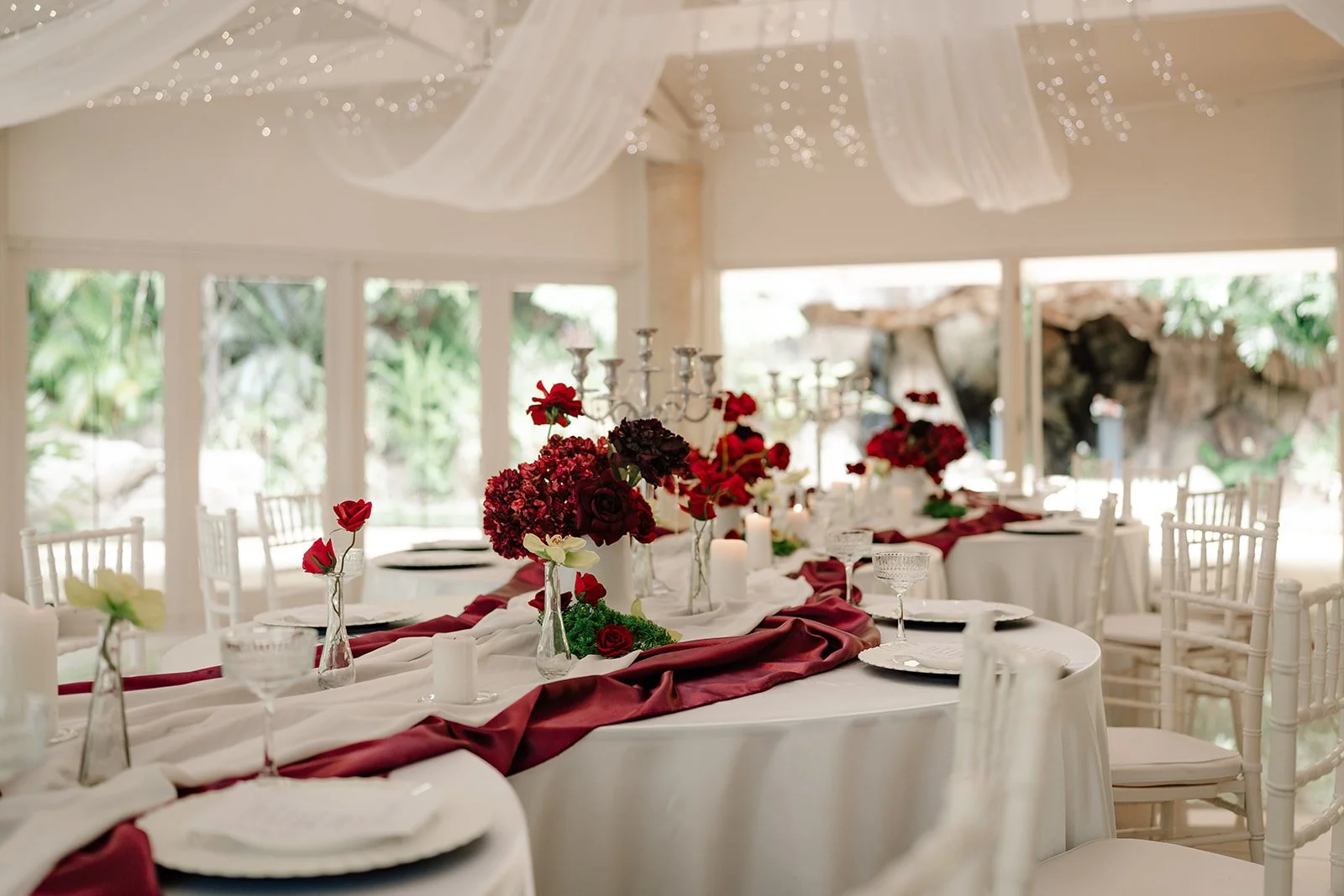 White fabric draping and fairy lights above curved reception tables in the Waterfall Pavilion