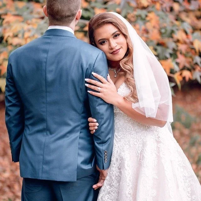 Newlyweds sharing a quiet embrace among autumn leaves at Shambala Estate on Tamborine Mountain