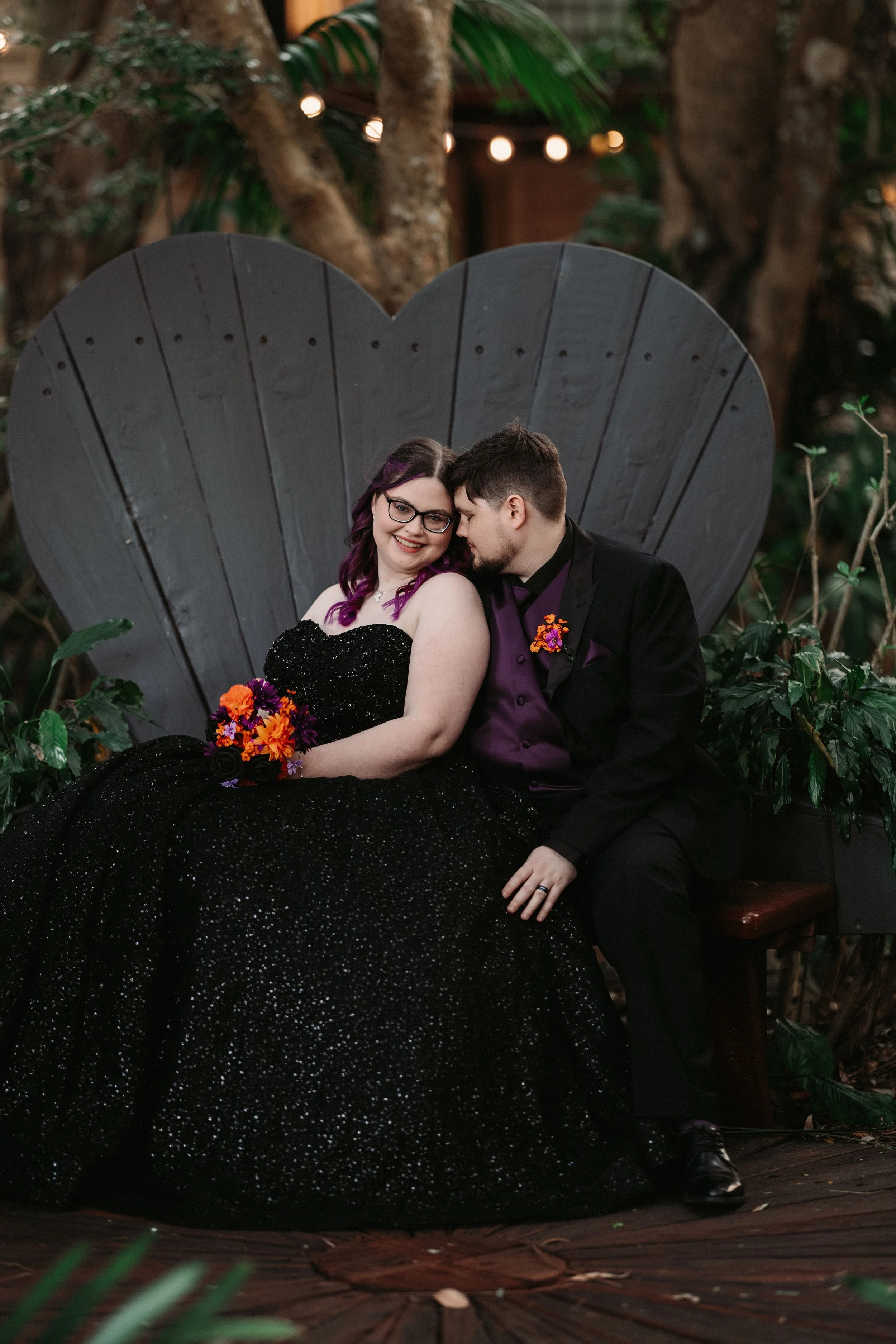 Wedding couple seated together on the heart-shaped garden chair at Shambala Estate.