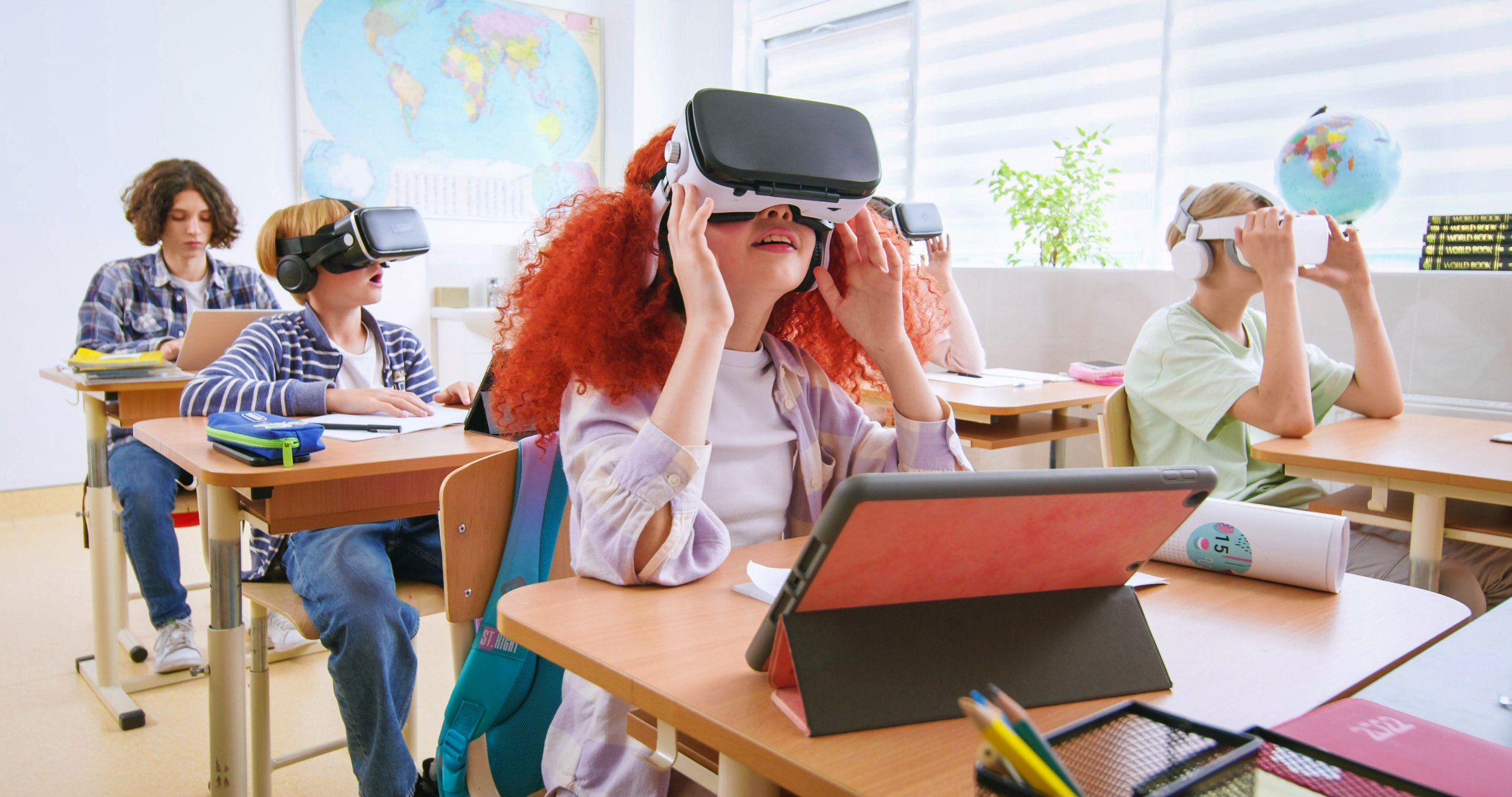 Students wearing virtual reality headsets in a classroom with educational posters and globes.