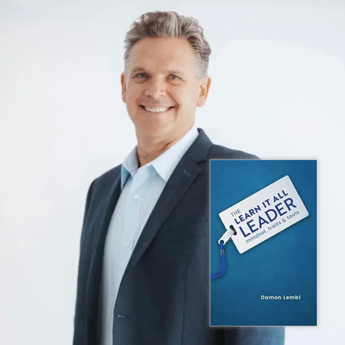 A smiling middle-aged man in a dark suit and white shirt standing against a plain background, with an inset of a book titled 'The Learn It All Leader' by Damon Lembi.
