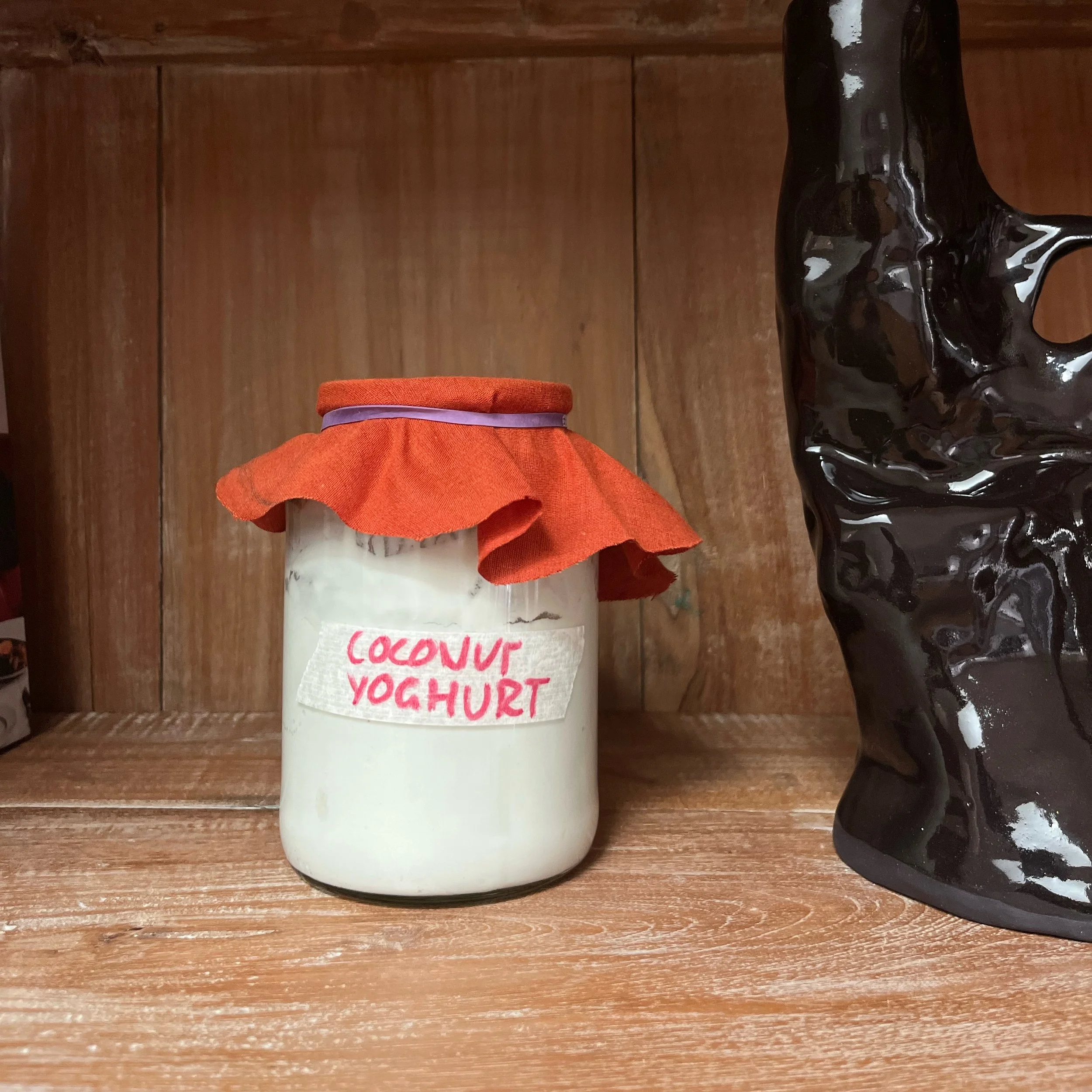 Tried something new &amp; it worked - Coconut yoghurt without the additives: 

1 can organic coconut milk 
2 multi strain probiotic capsules opened 
Dollop of plain &ldquo;living coconut&rdquo; yoghurt 

Natural fibre cloth on top, sat it in the cupb