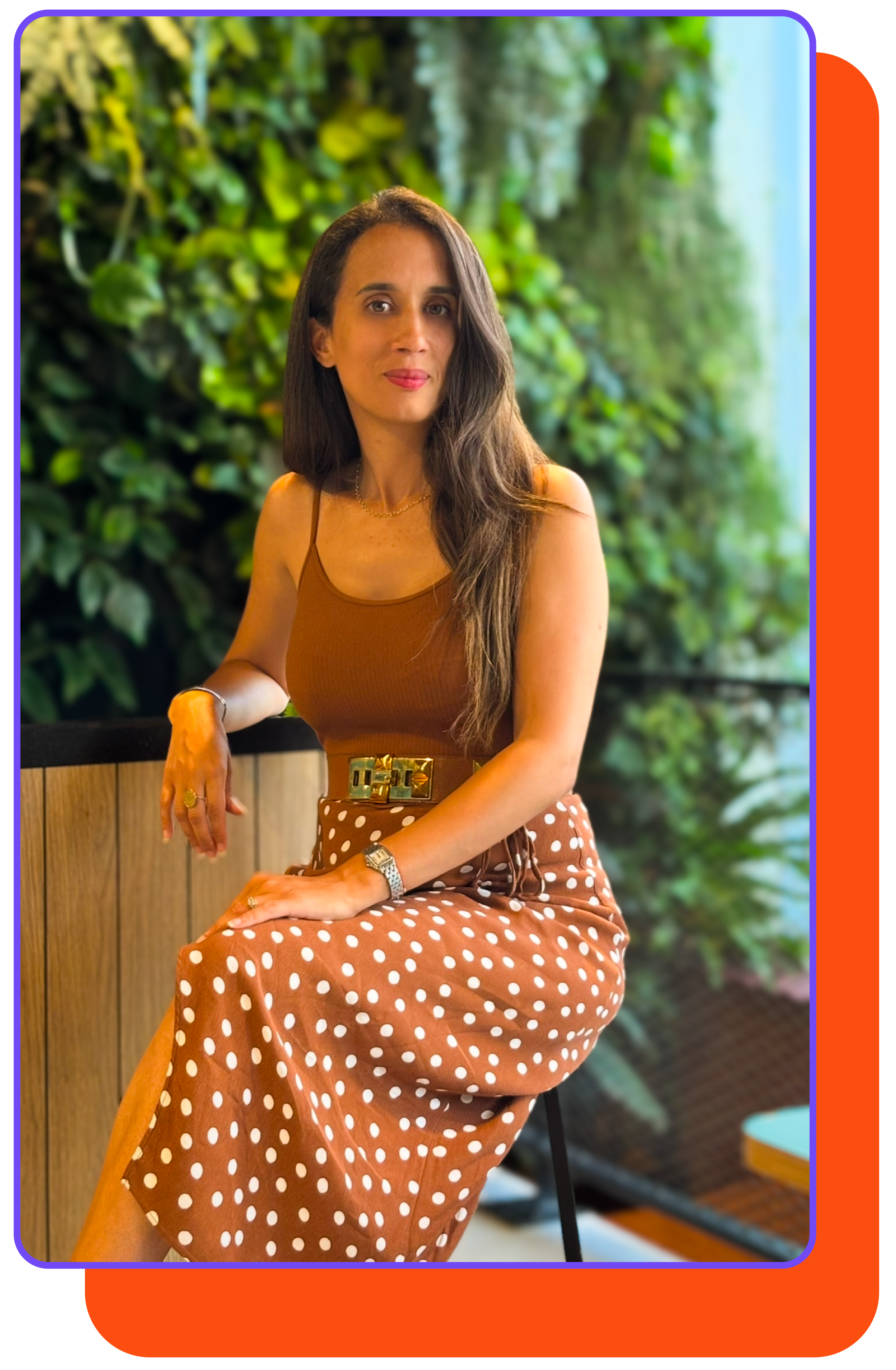 Meriem Houani, fondatrice de Noo, assise en extérieur devant un mur végétal.