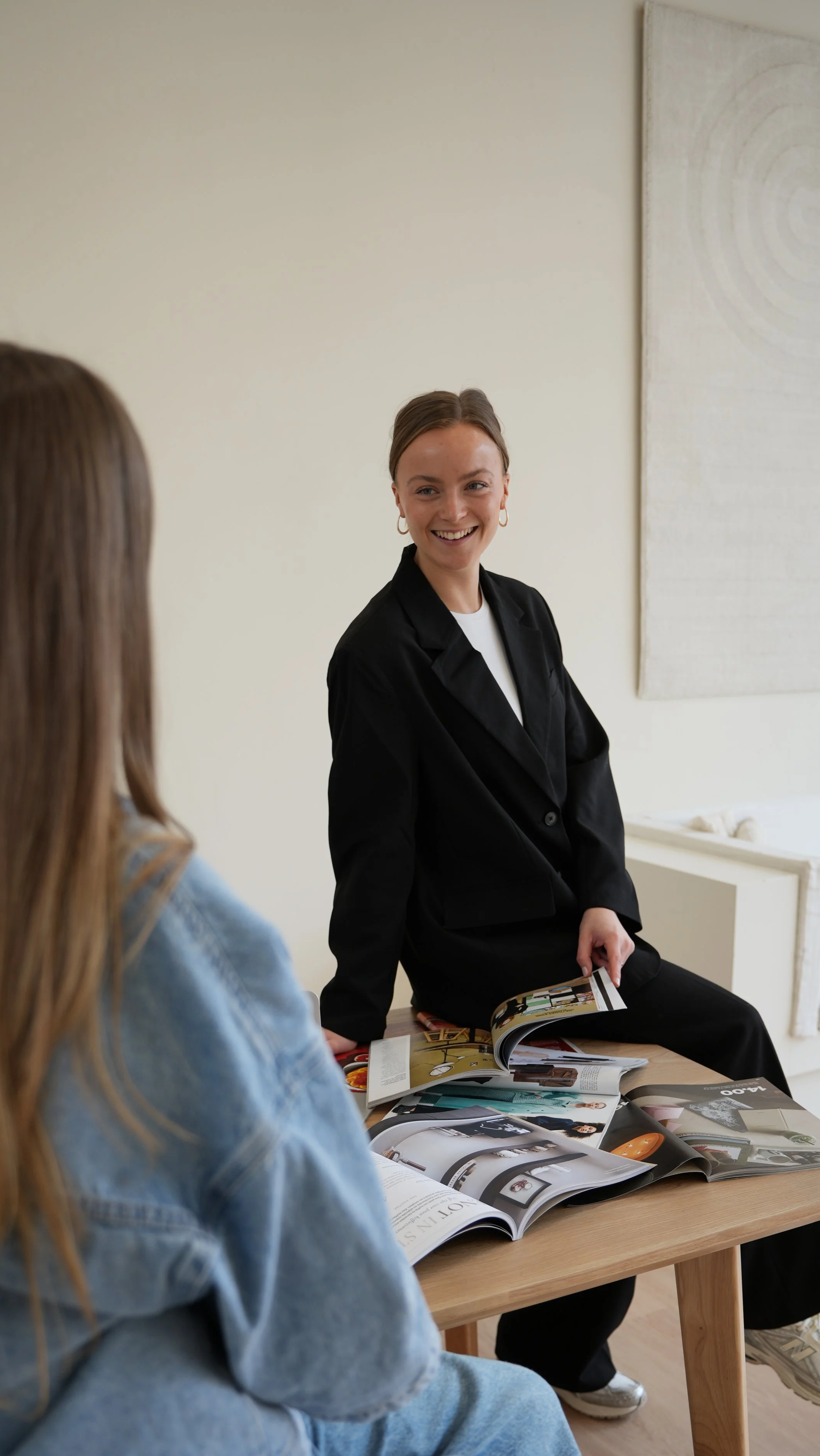 Julia van JUNE content creation, lachend en zittend aan tafel voor content en social mediaplanning.