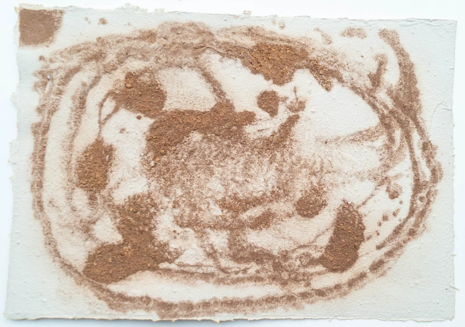 Coffee or cocoa powder on a surface arranged to form a portrait of a person with glasses, curly hair, and a broad smile.