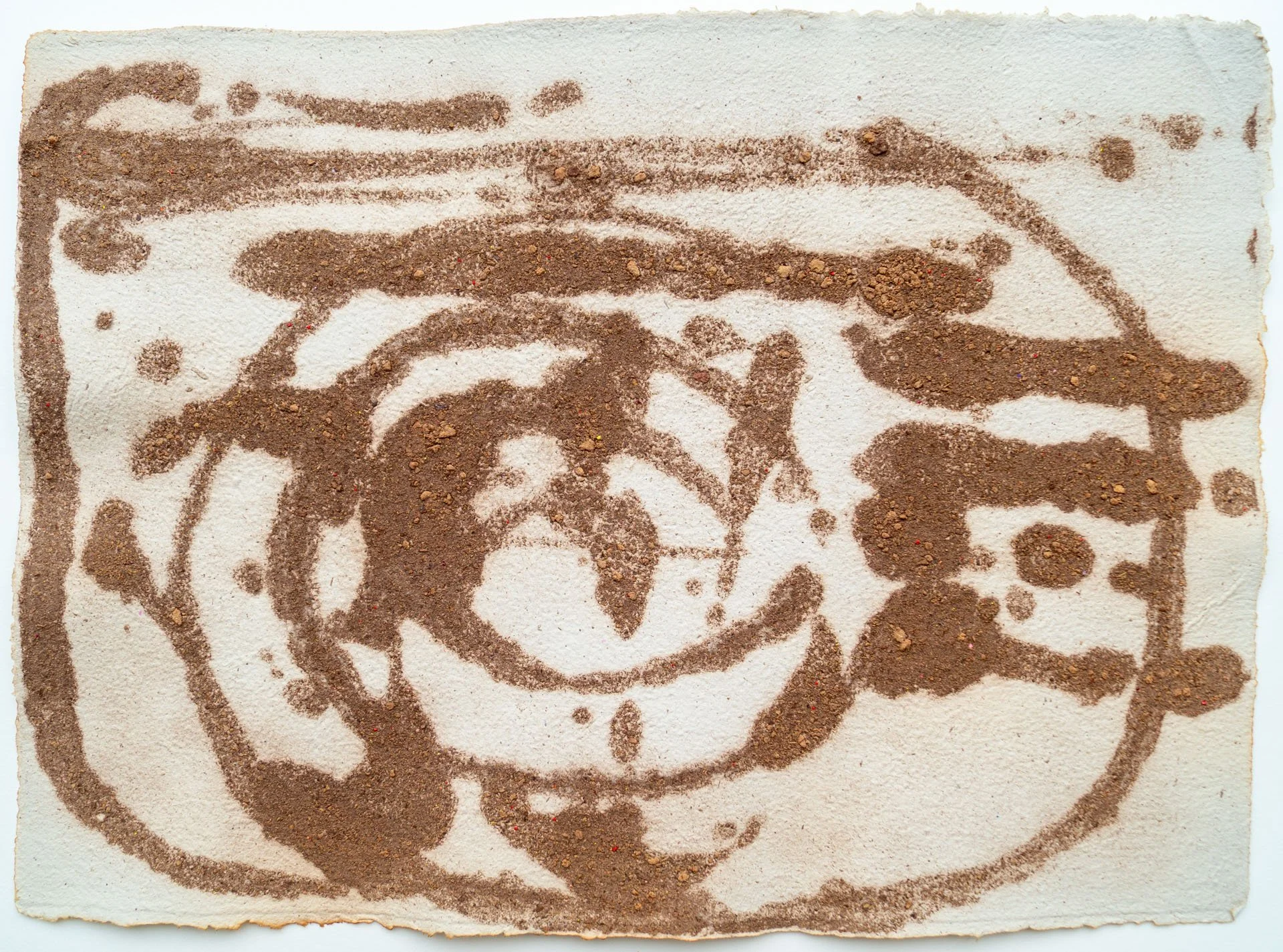 Coffee-spilled pattern on white paper with a design resembling a face or a figure.