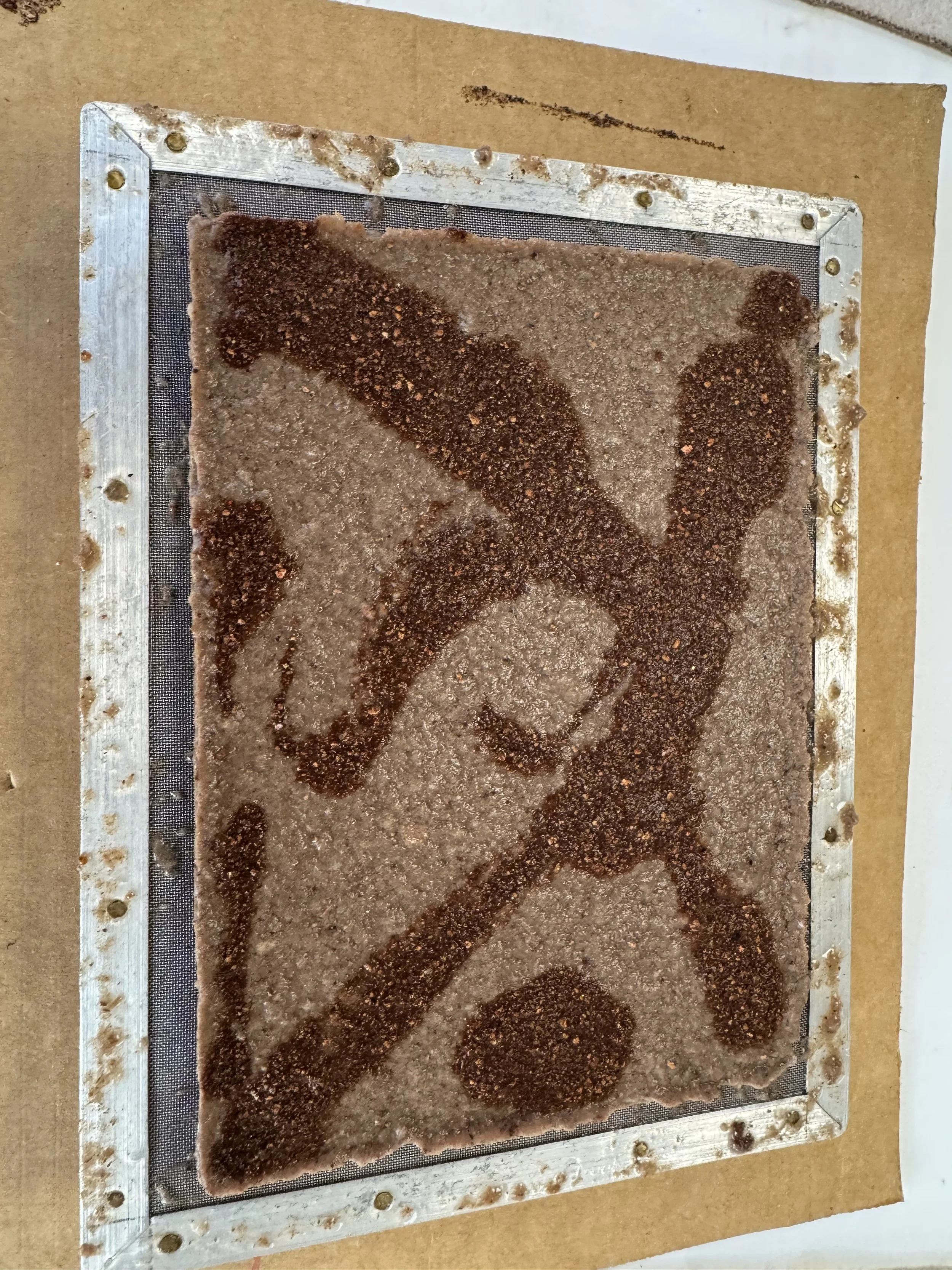 Unbaked rectangular baking sheet with raw brownie batter, decorated with cinnamon and sugar in the shape of angels or fairy wings on top.