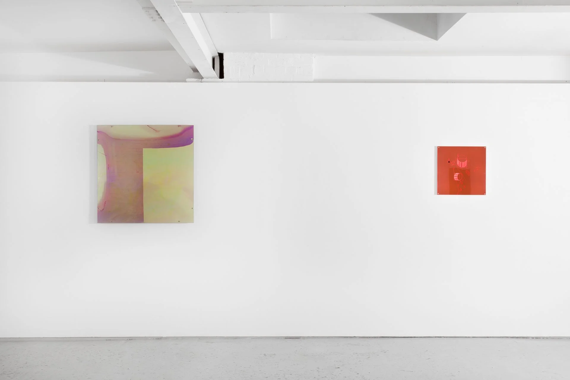 Two abstract paintings are displayed on a white gallery wall, one larger with shades of purple, pink, and green, and one smaller with a bright red background and darker elements.