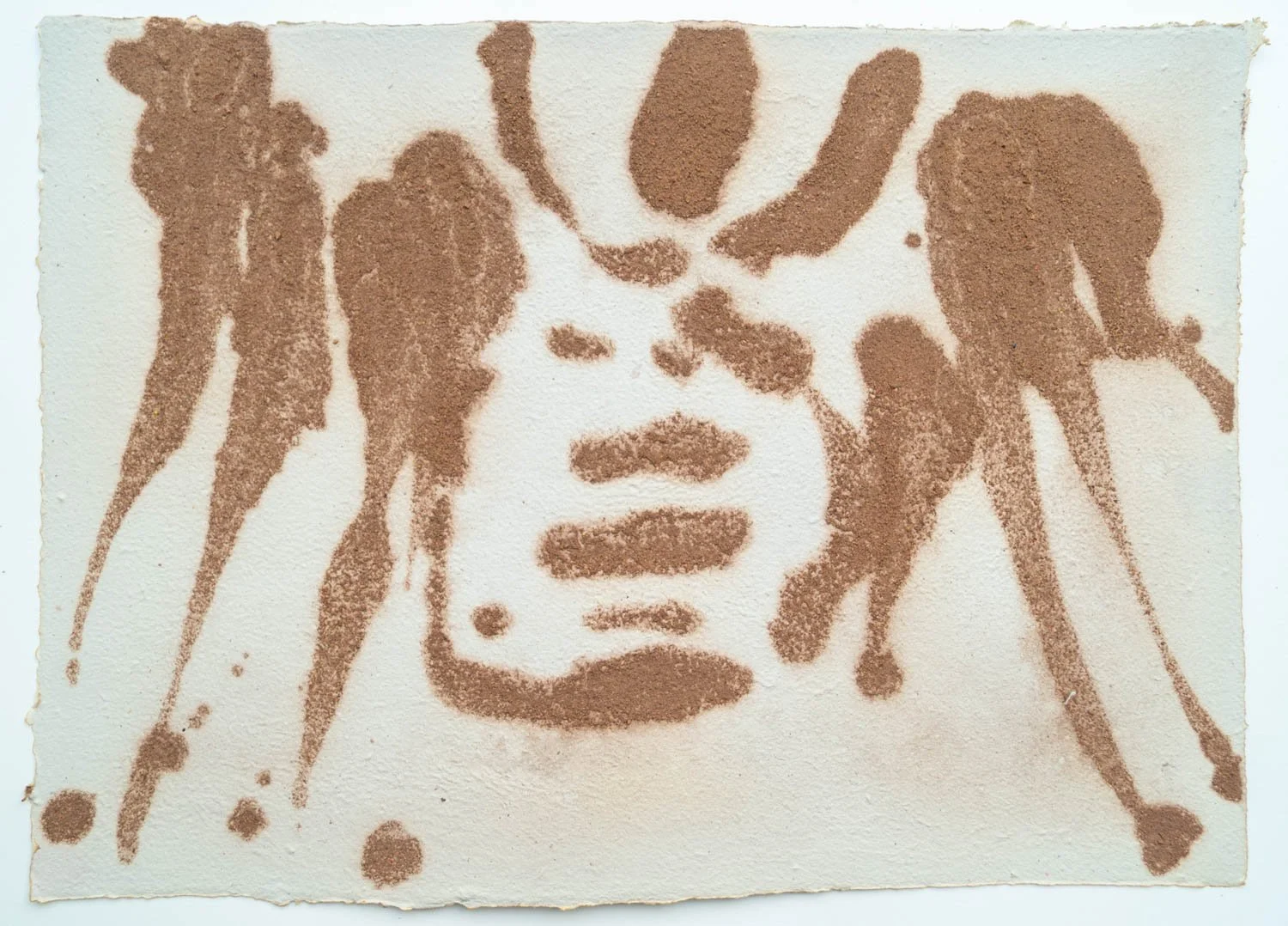 Abstract portrait of a face created using brown textured material on white paper.