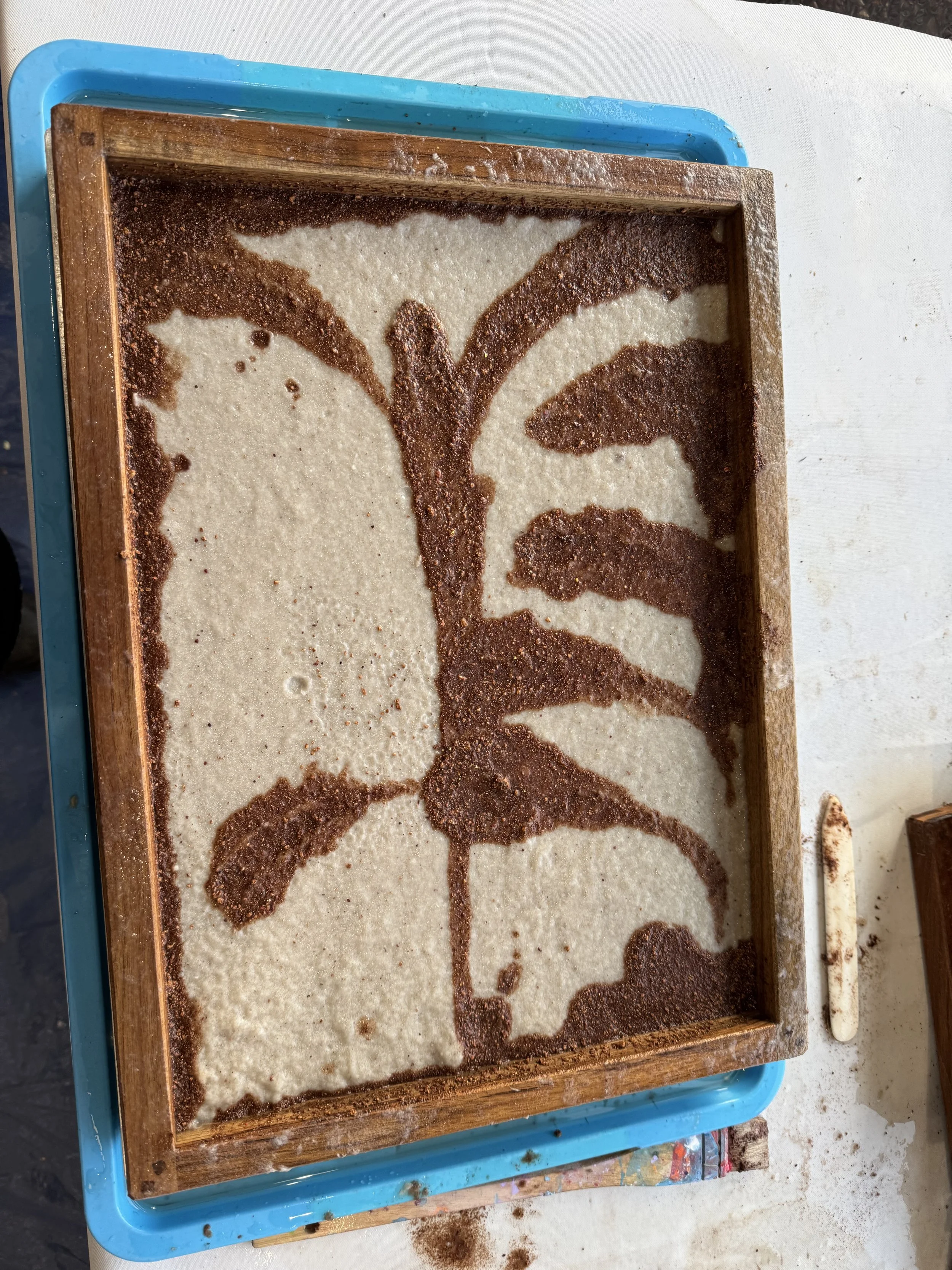 A wooden tray with a design made from cocoa powder or cinnamon on a light-colored surface.