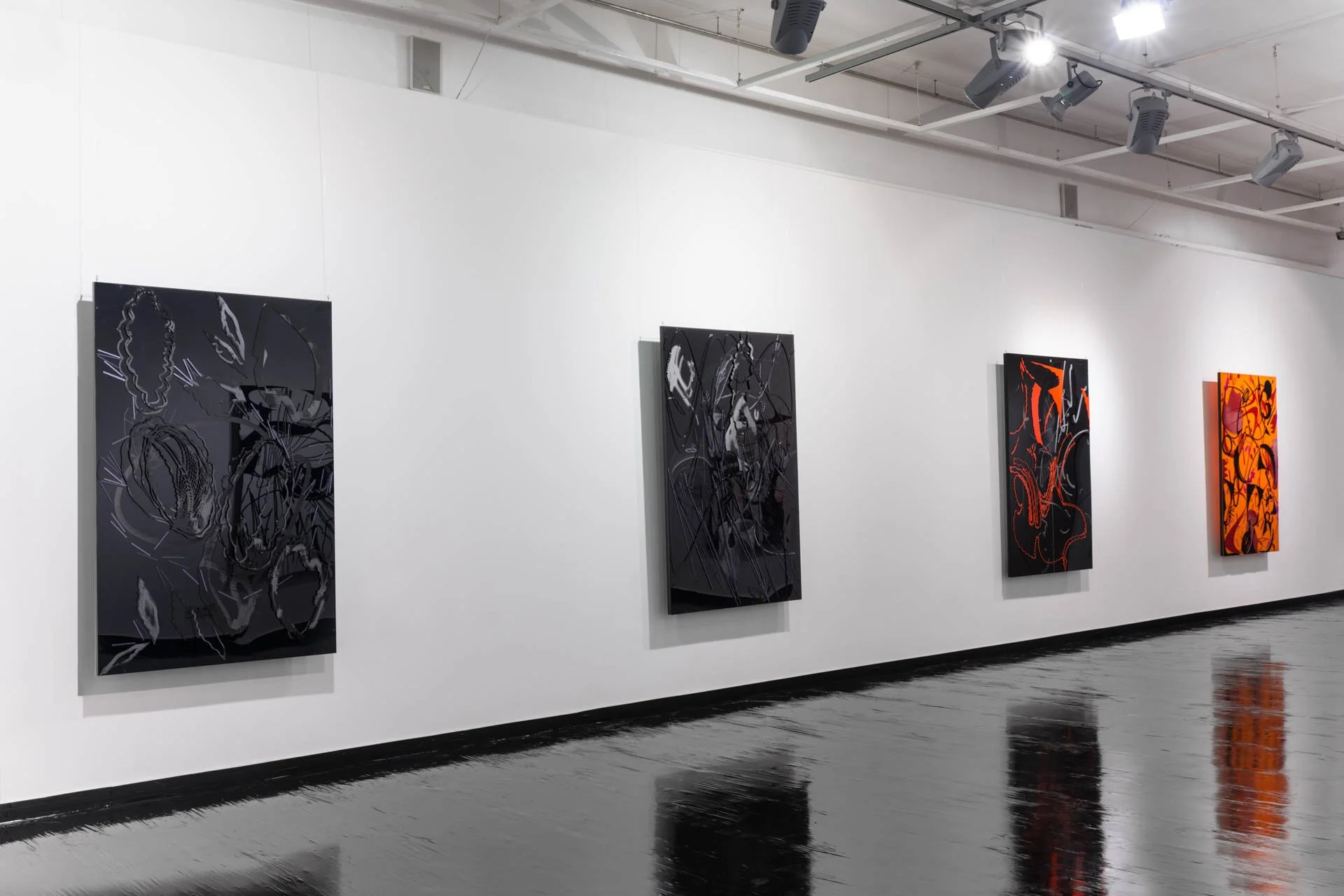 A contemporary art gallery with four large abstract paintings on a white wall, illuminated by ceiling track lights.