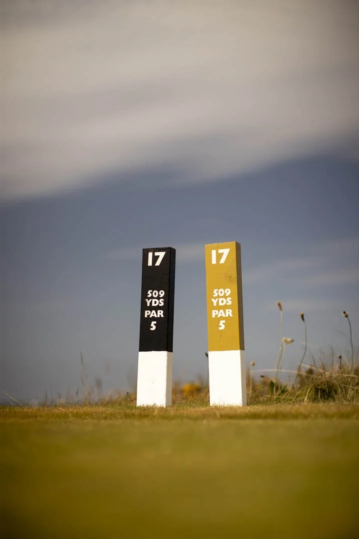 Two marker posts on a golf course fairway showing hole number 17, 509 yards to the green, with a par of 5.