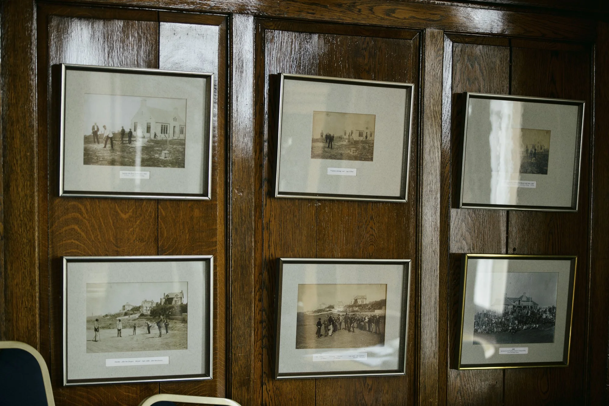 Six framed black-and-white historical photographs displayed in the Moray Golf Club clubhouse